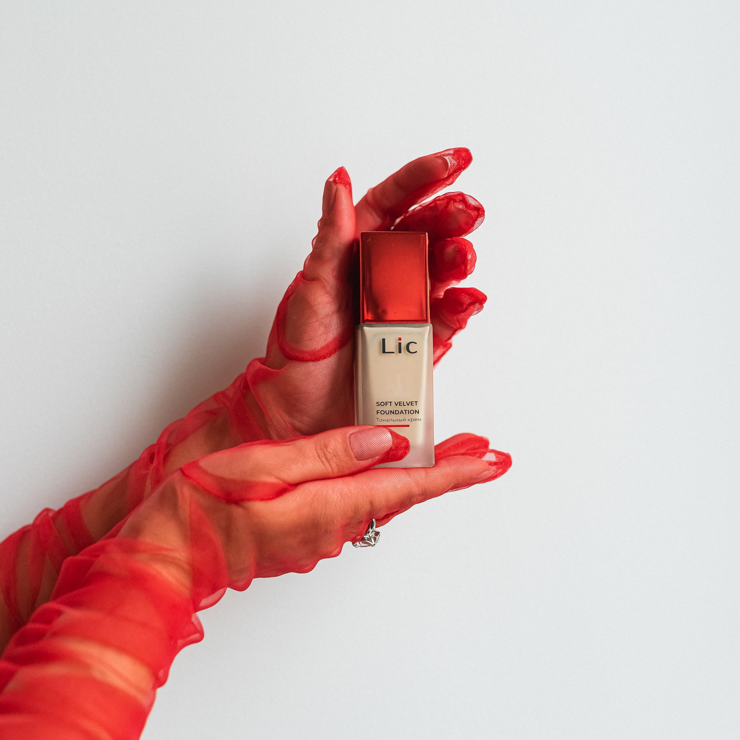 фото тонального крема с красными перчатками