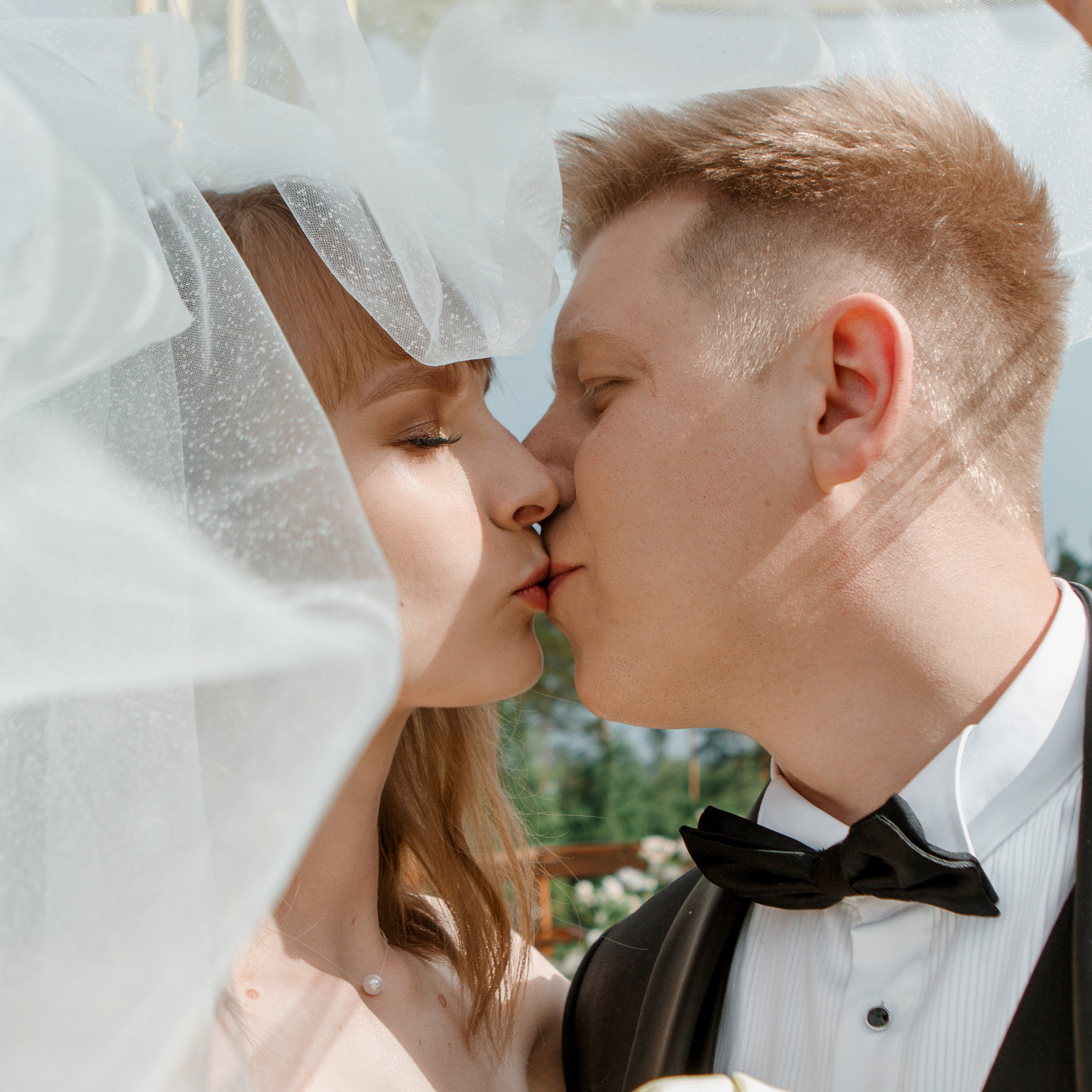 молодожёны целуются под фатой 