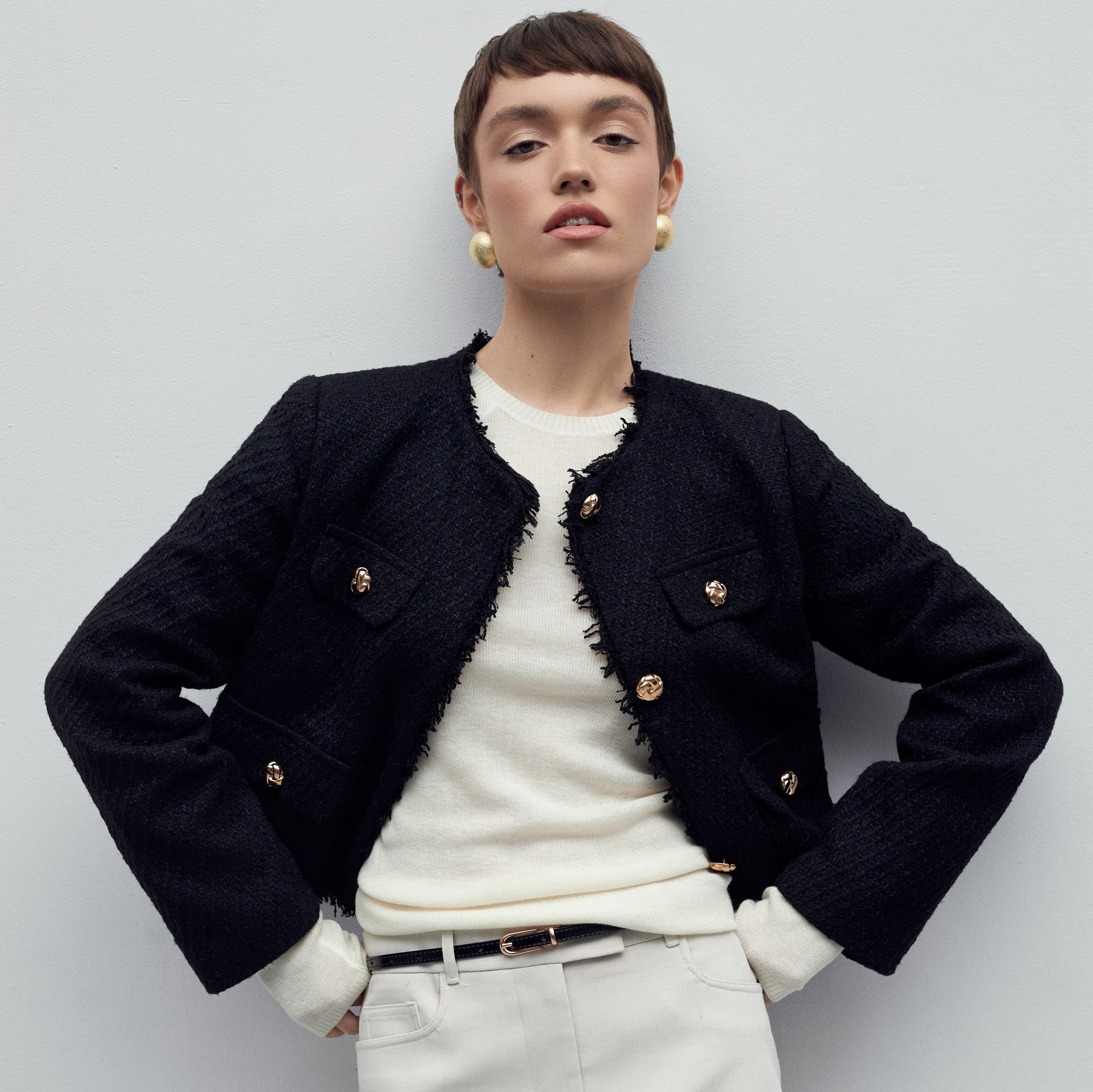 Студийное фото девушки на стуле, на светло-сером фоне