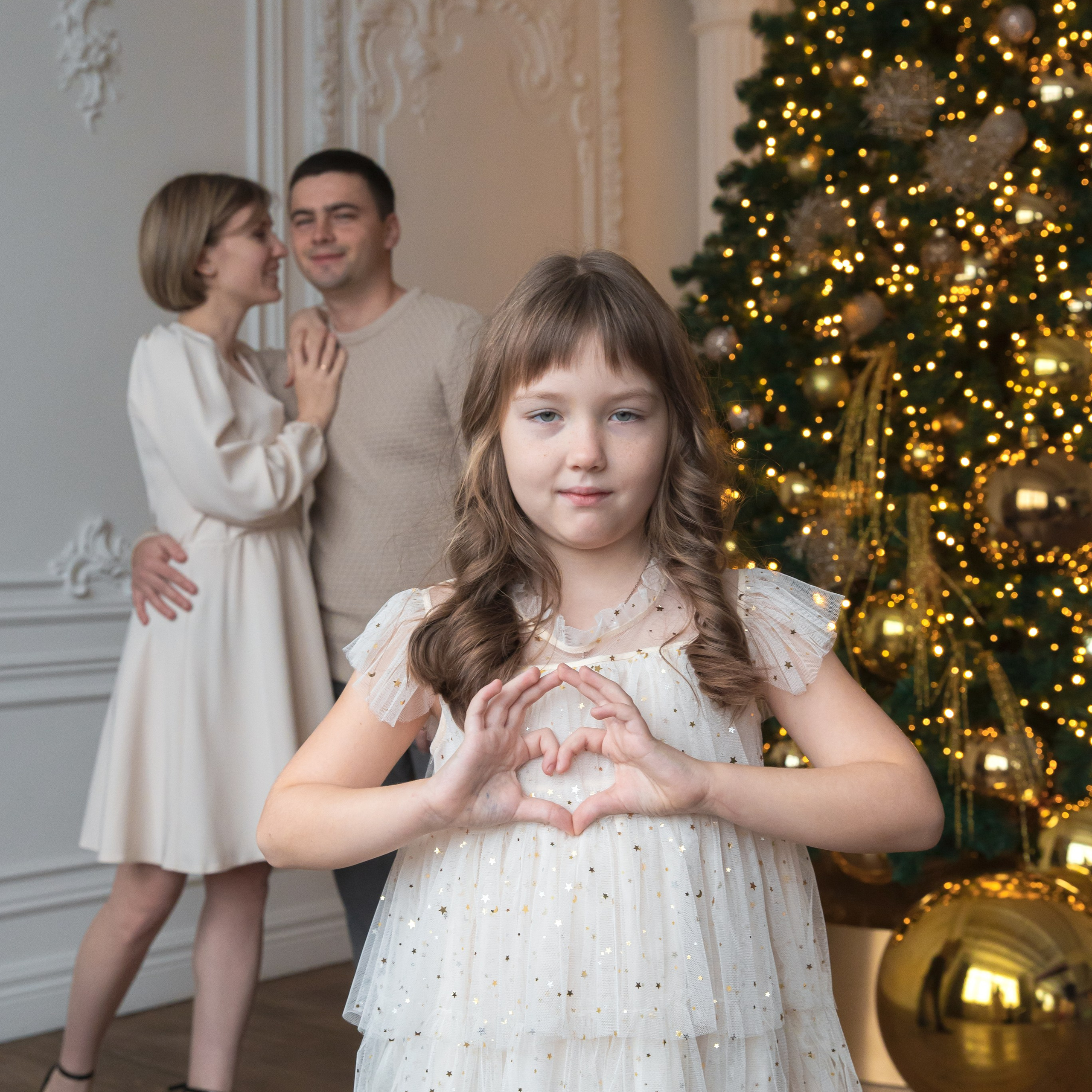 Семья, мама, папа и дочка позируют в фотостудии на фотосессии