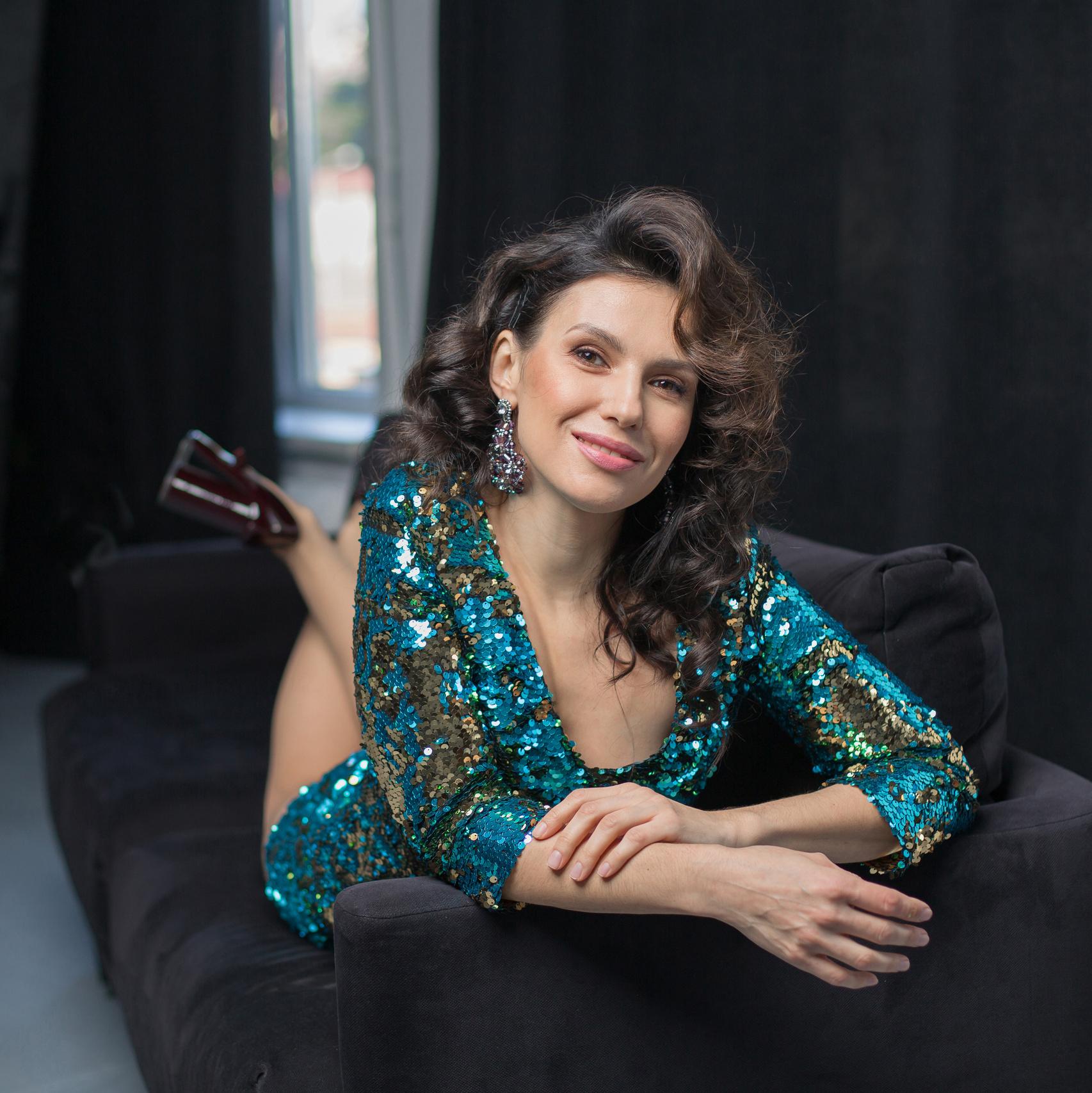 девушка в красивом платье лежит на диване