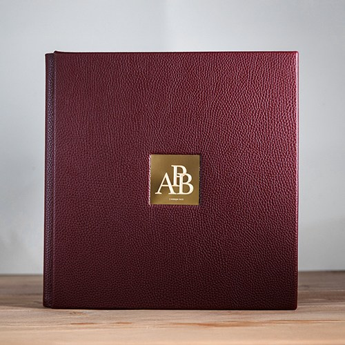 Эксклюзивная фотокнига из натуральной кожи бордового цвета с золотой металлической шильдой.