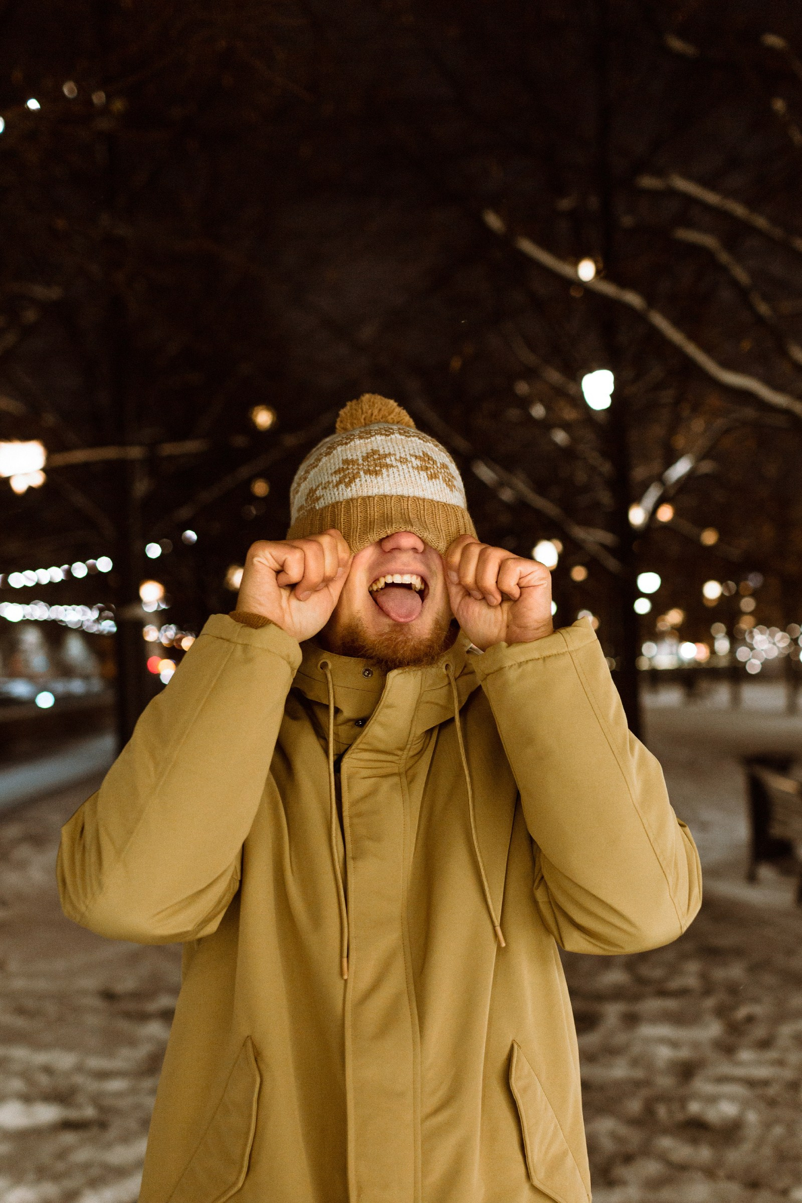 Фотопрогулка зимой в Санкт-Петербурге: живой мужской портрет в шапке в ночных огнях.