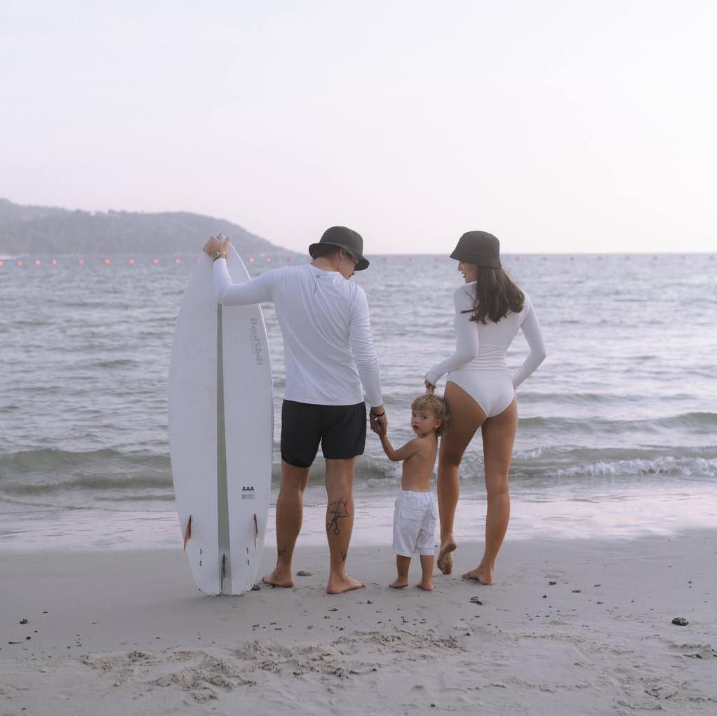 Семья с ребёнком на пляже со спины