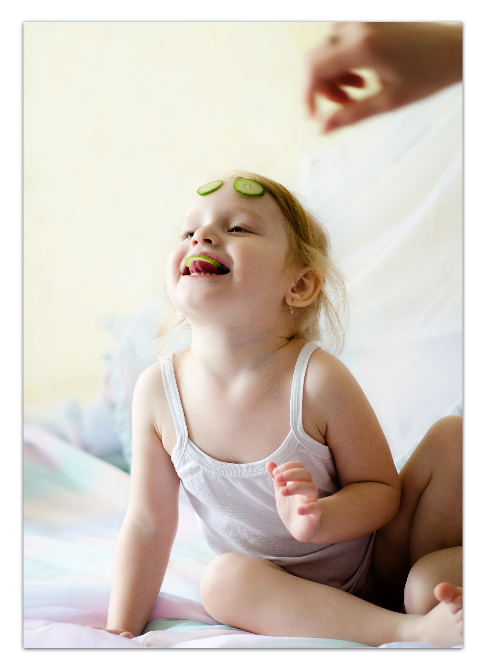 Домашние будни без прикрас - маленький ребёнок в майке на кровати, мягкая солнечная атмосфера.