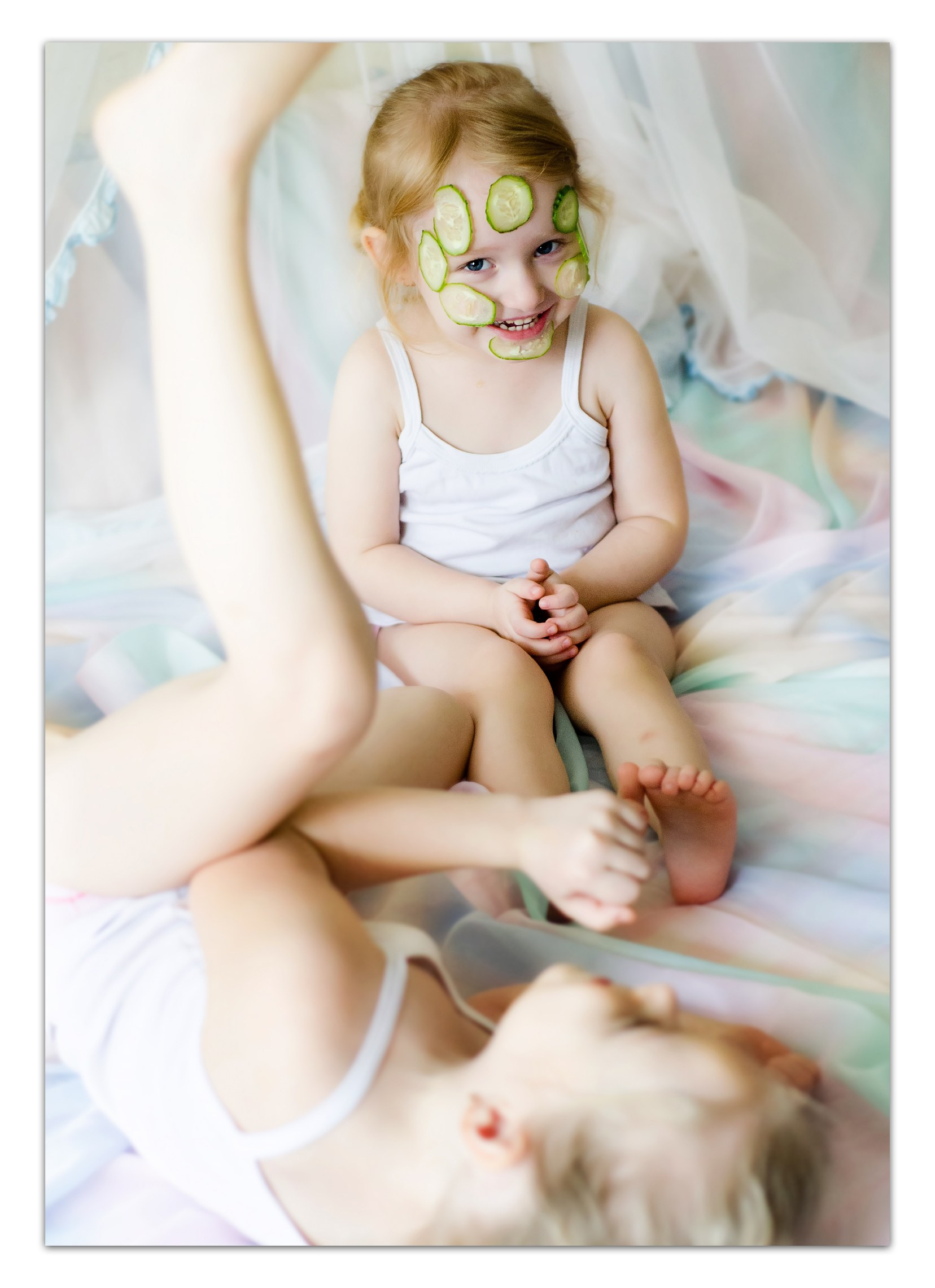 Домашняя фотосъемка в Кирове - две девочки в белой одежде на пастельной постели, уютно