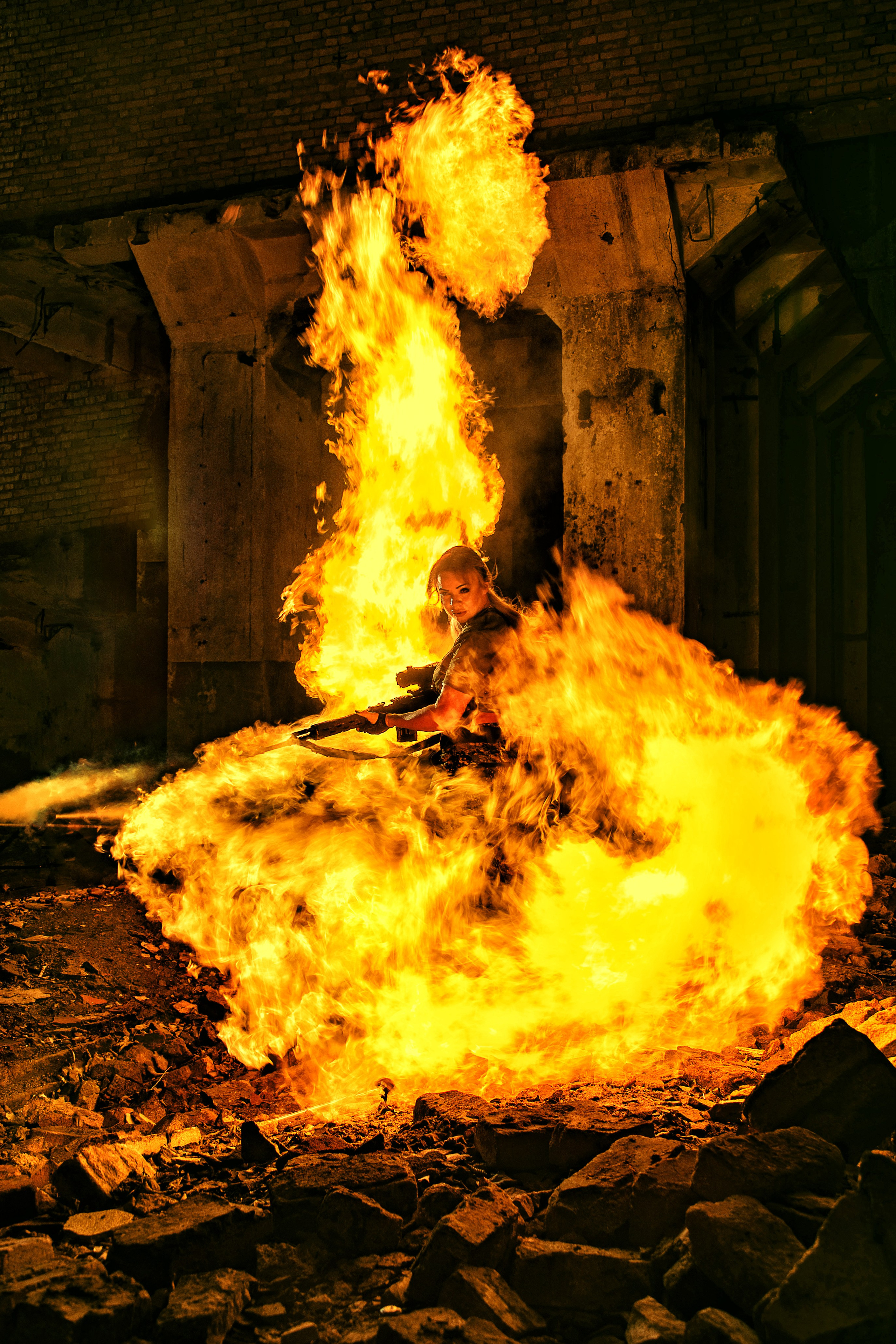 Девушка с винтовкой резко разворачивается в пламени огня