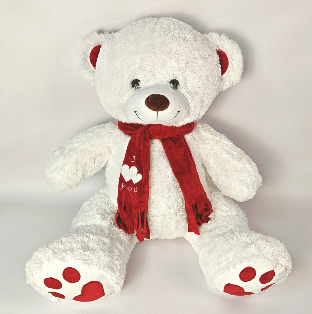 Фотография большой мягкой игрушки - медведь на белом фоне