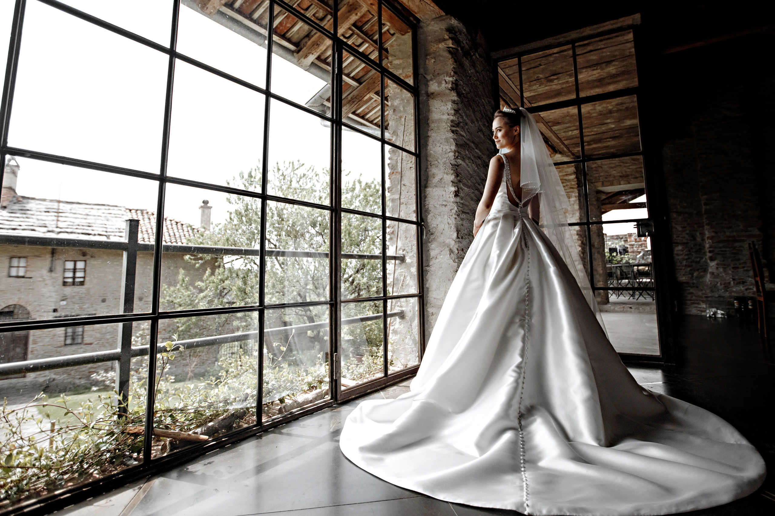 невеста в свадебном платье стоящая у окна