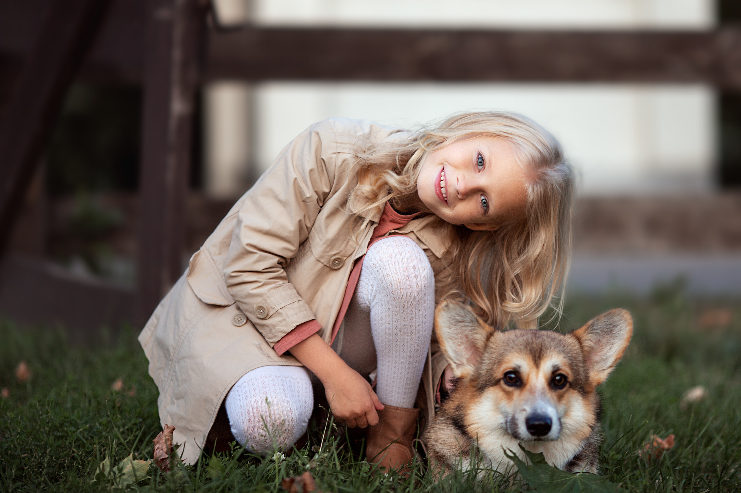 Девочка с собакой сидит в парке Коломенская