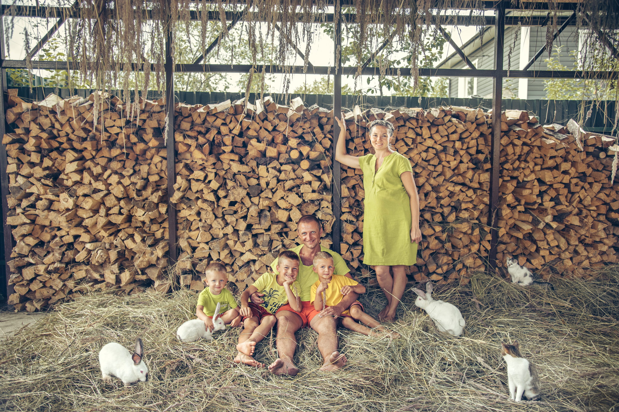 летняя семейная фотосессия у поленницы с тремя детьми, зайцами и кошками