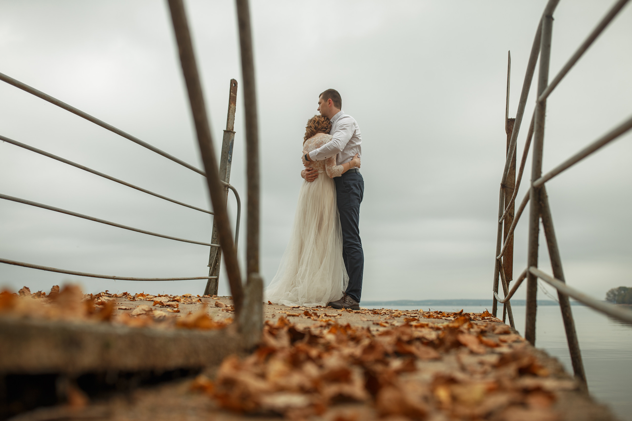 Свадебная прогулка красивой пары на берегу озера