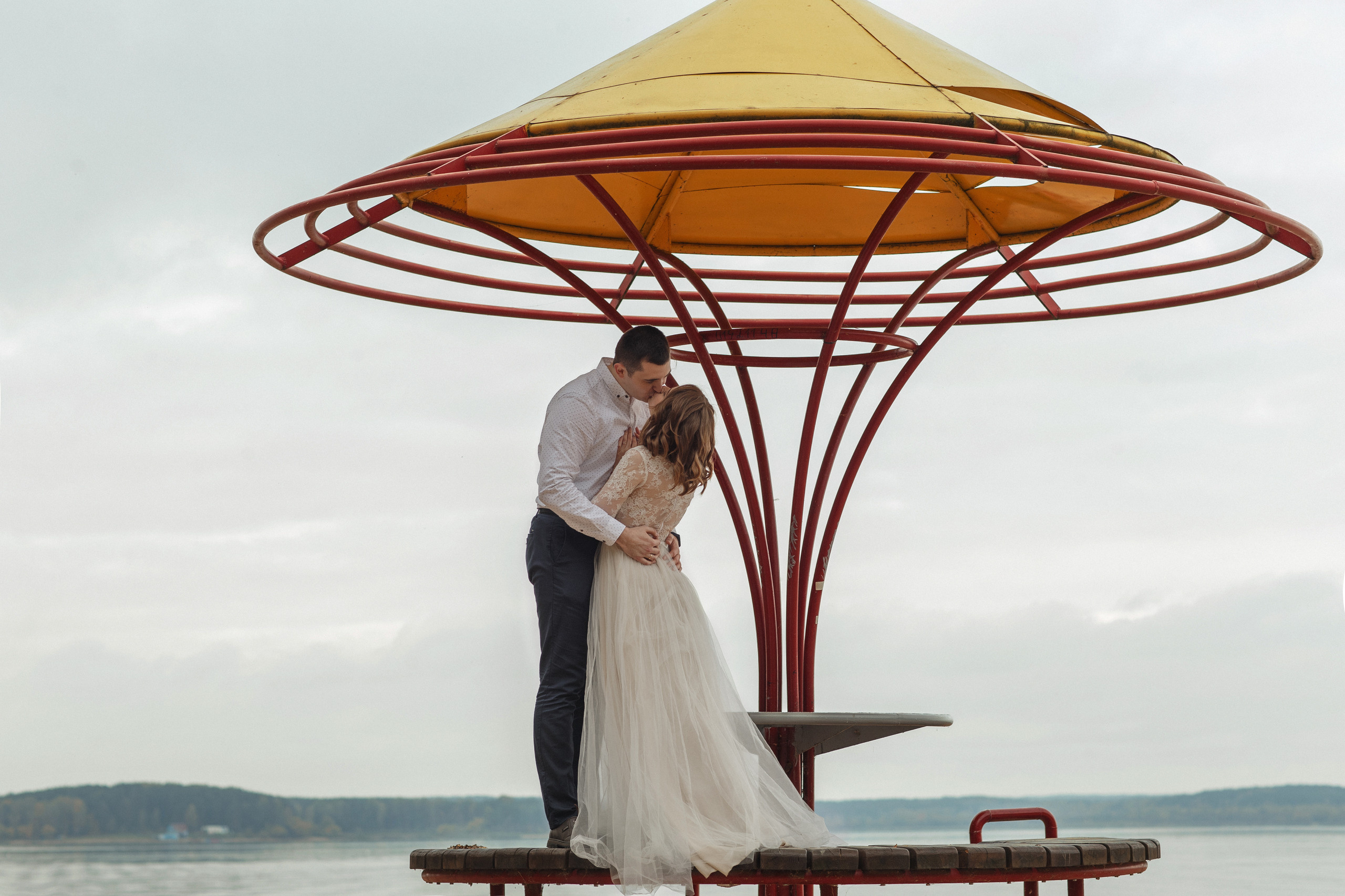 Свадебная прогулка красивой пары на берегу озера