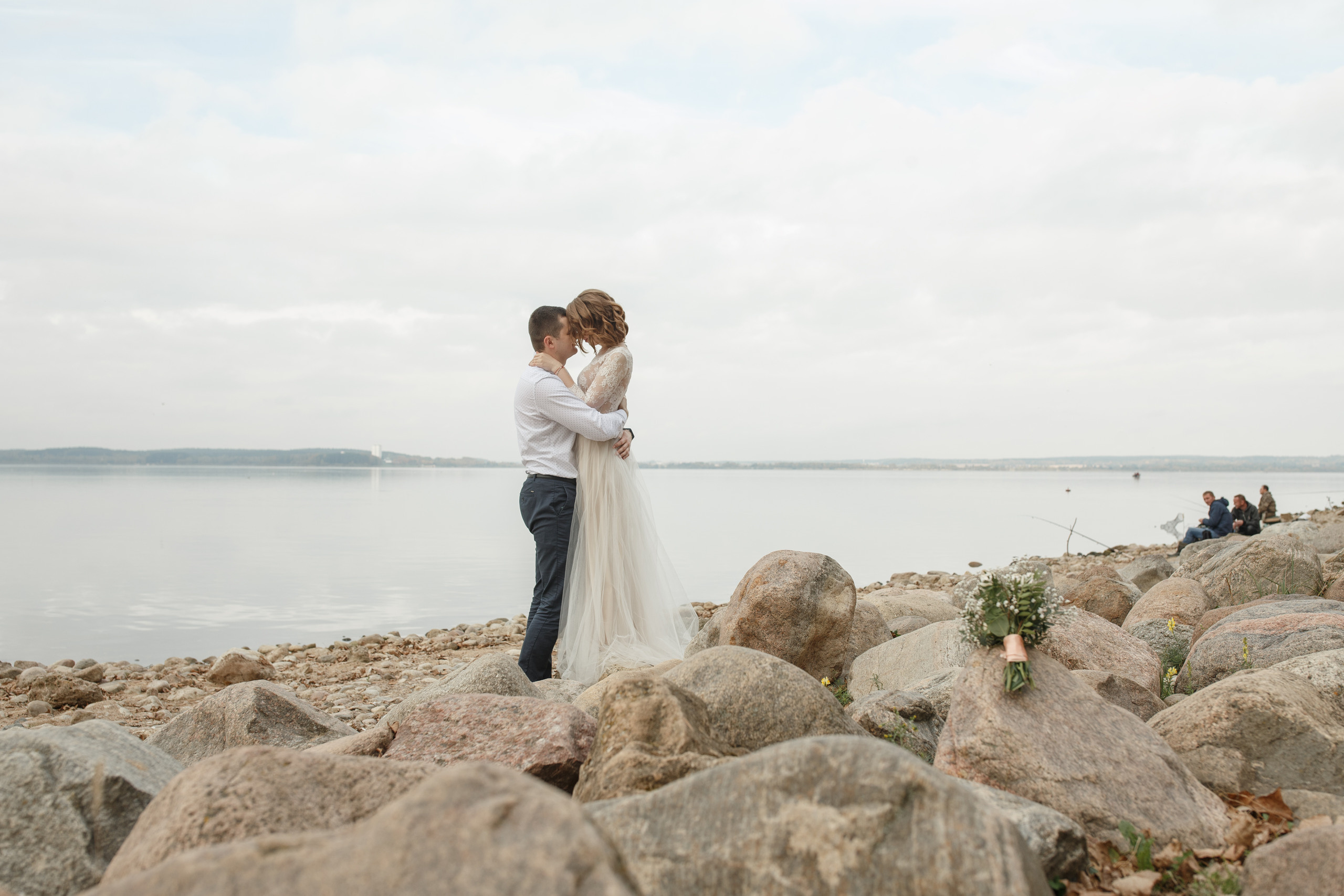 Свадебная прогулка красивой пары на берегу озера