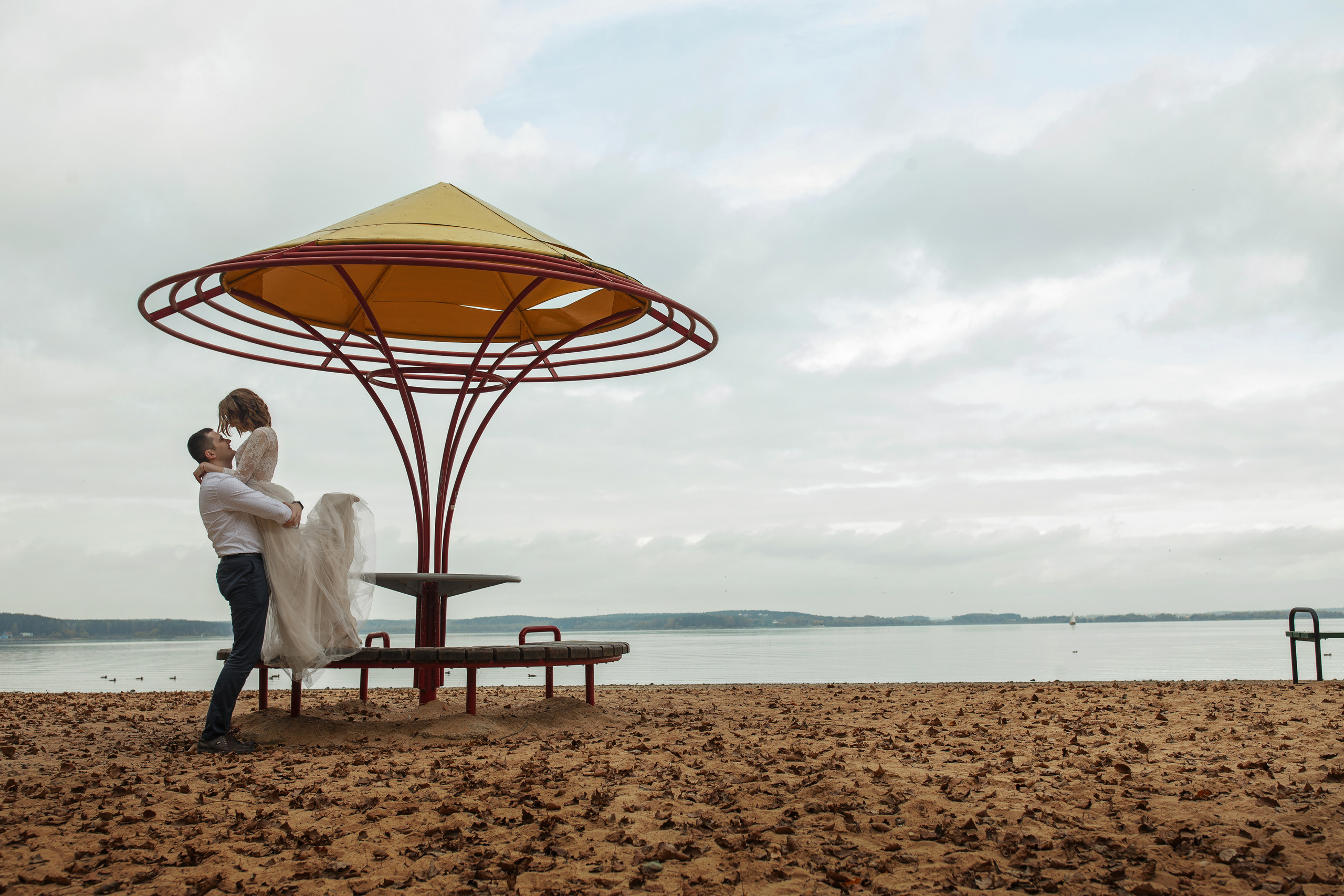 Свадебная прогулка красивой пары на берегу озера