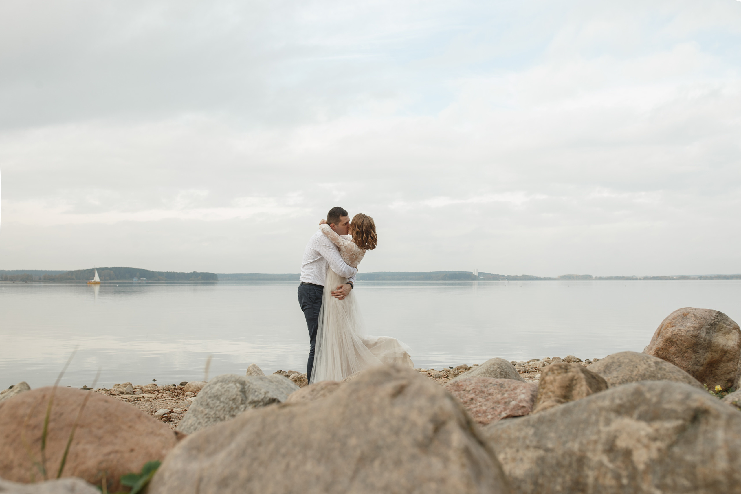 Свадебная прогулка красивой пары на берегу озера