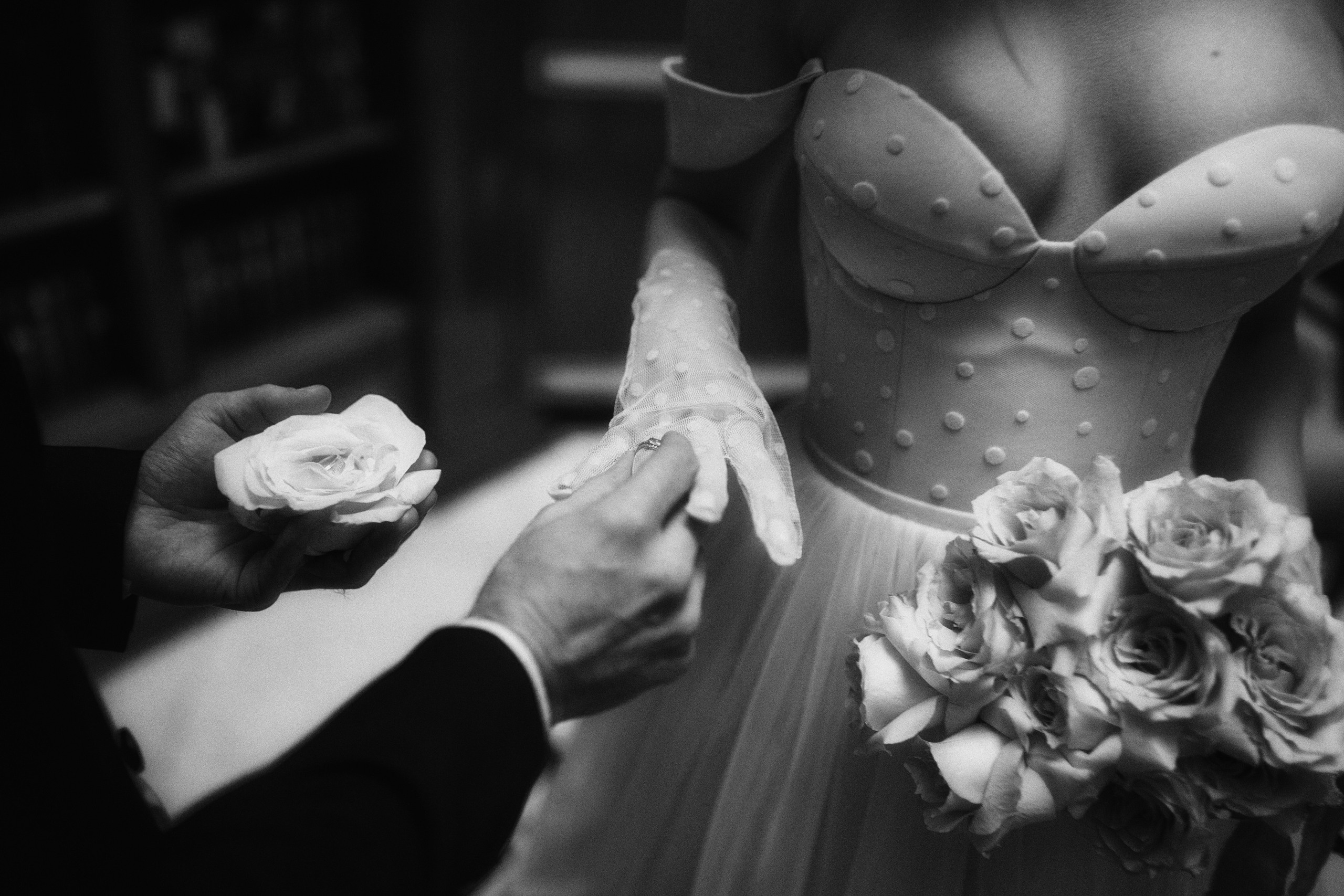 Жених надевает невесте на палец обручальное кольцо с бриллиантом. 