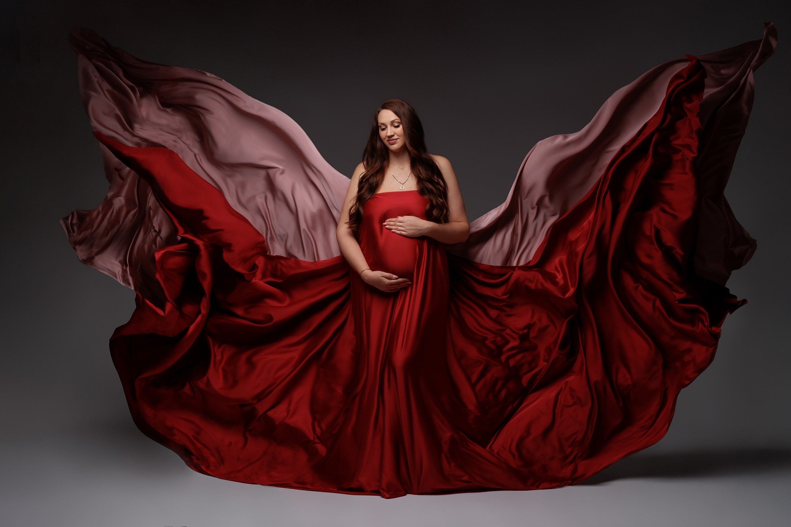 Беременная женщина в парящих тканях