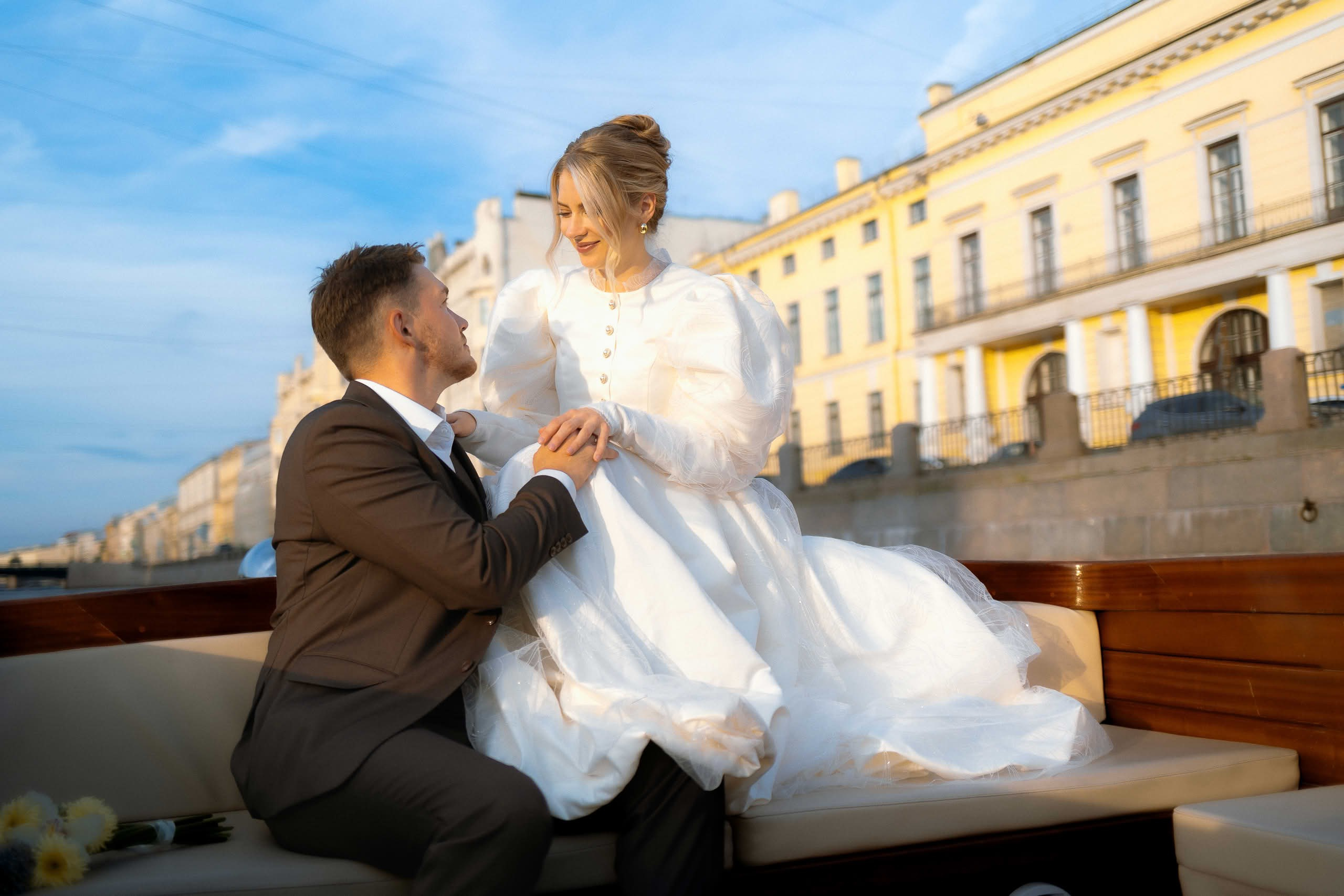 Молодожёны на катере во время свадебной фотосессии в Петербурге