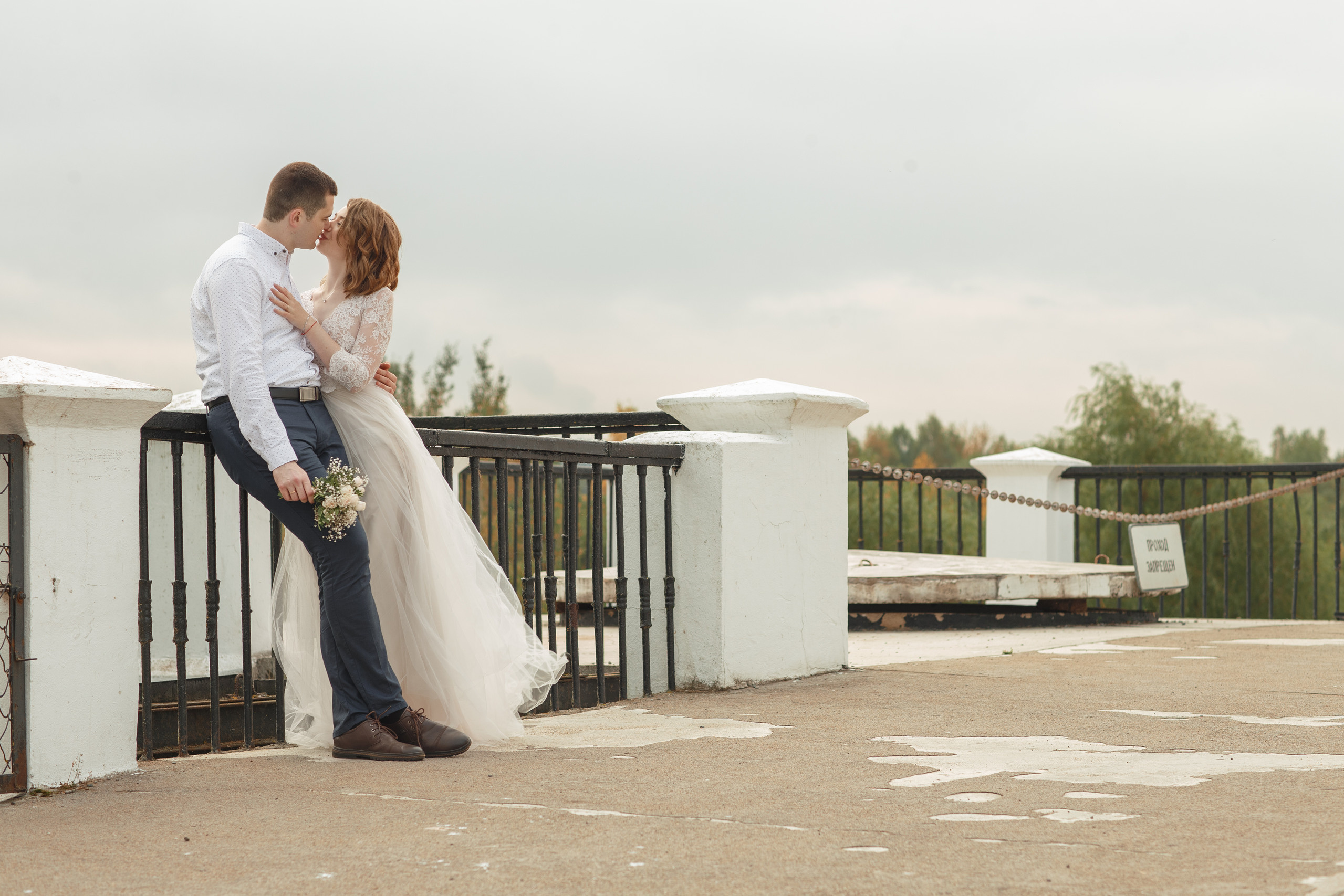 Свадебная прогулка красивой пары на берегу озера