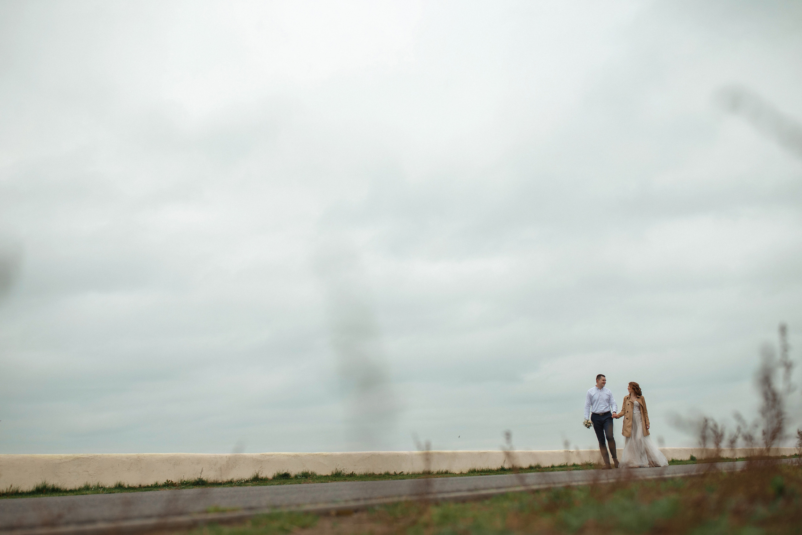 Свадебная прогулка красивой пары на берегу озера