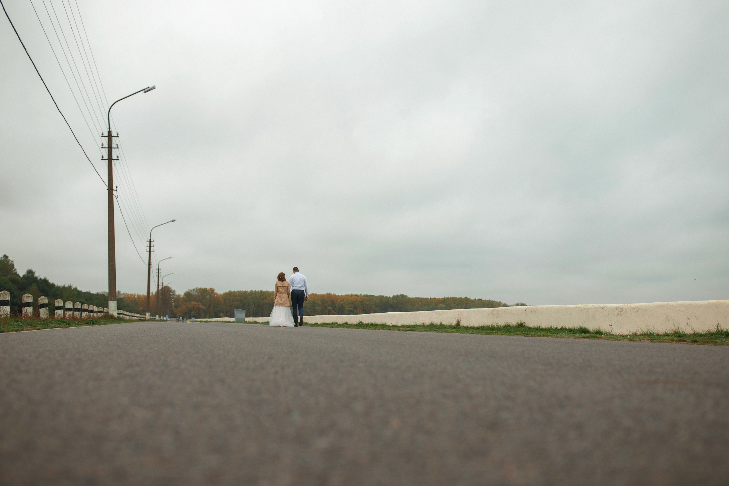 Свадебная прогулка красивой пары на берегу озера