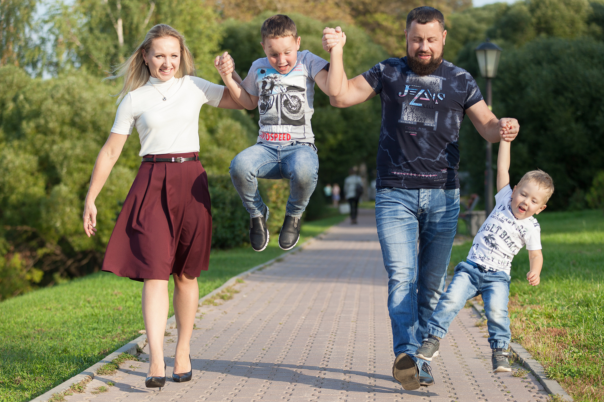 семья на улице, два сына держат за руку родителей