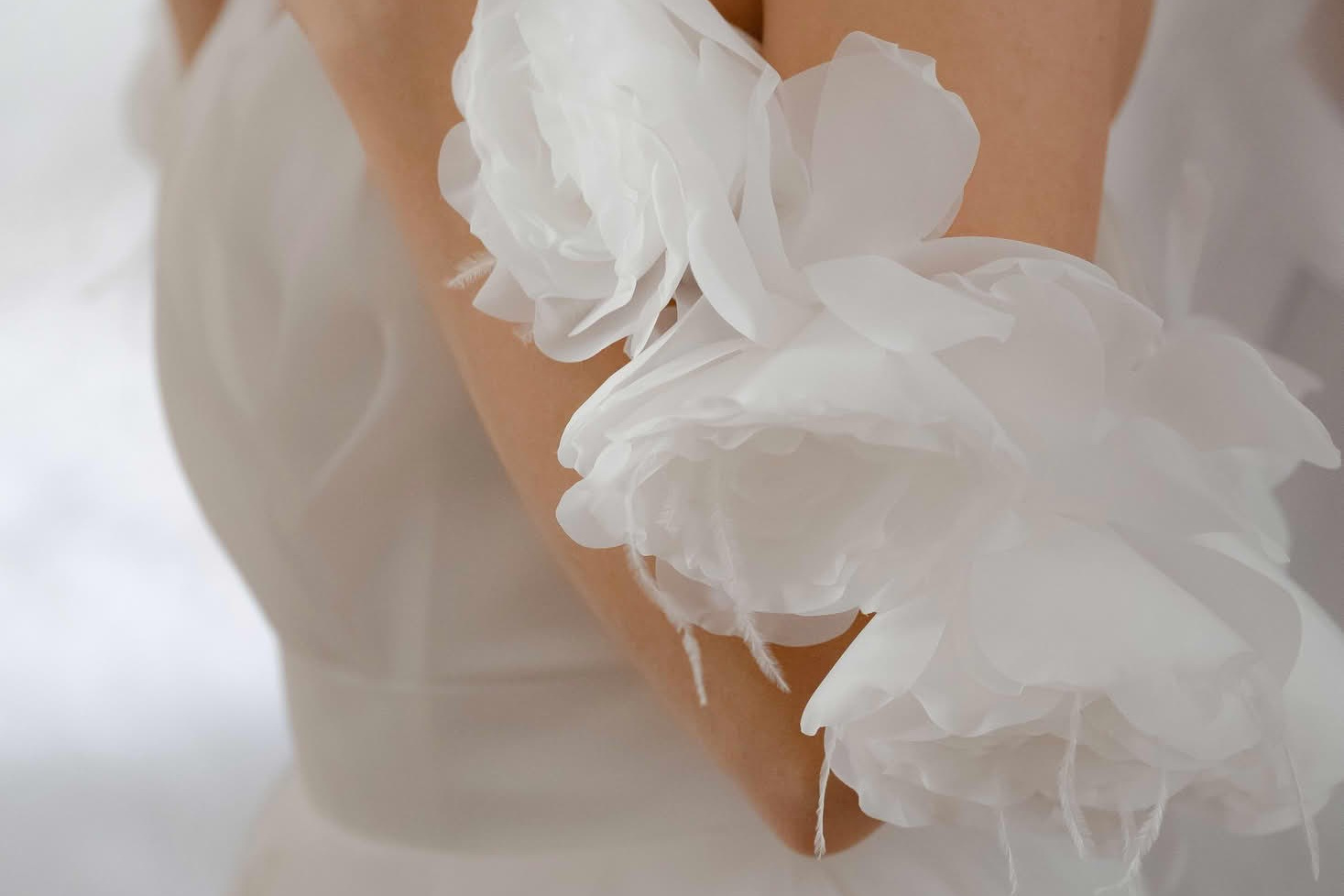 Невеста держит руки у груди, акцент на деталях платья и рукавах