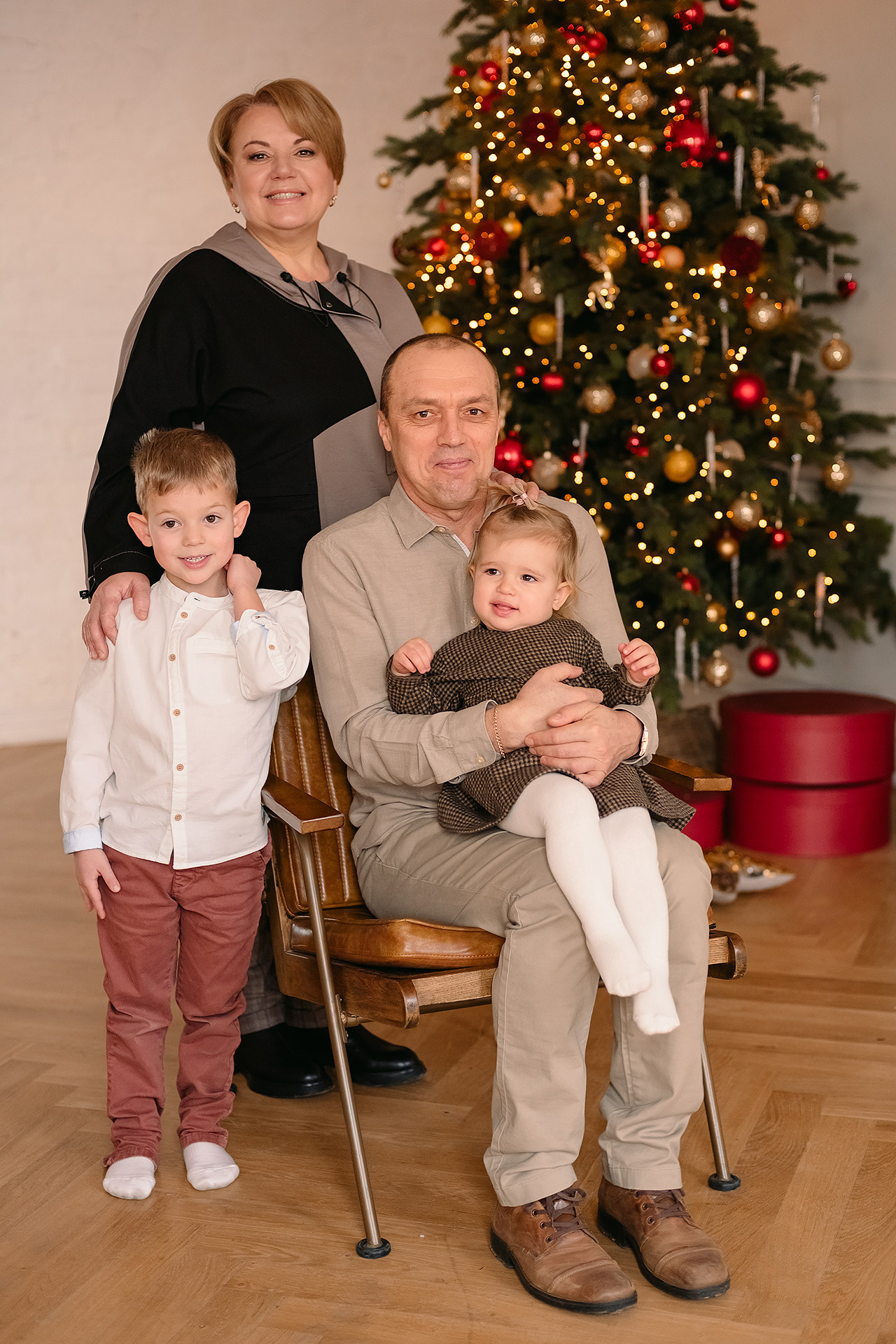 бабушка и дедушка с внуками на фоне елки