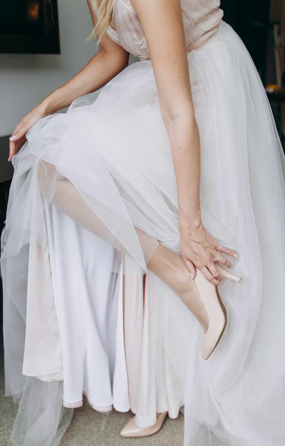 Невеста одевает свадебные туфли подняв ногу