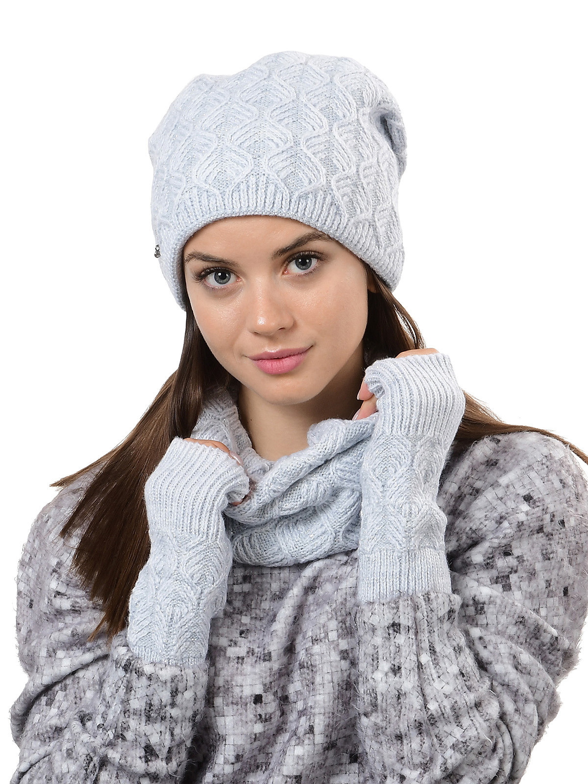 Модель в шапке и шарфе в студии на белом фоне.