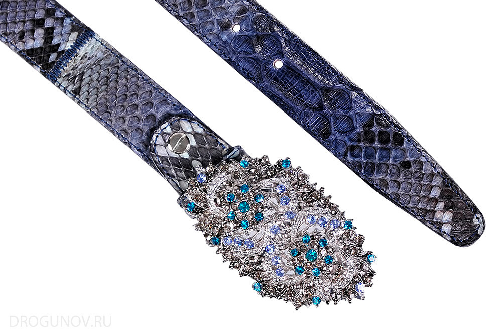 Ремень из кожи питона в разложенном виде на белом фоне.