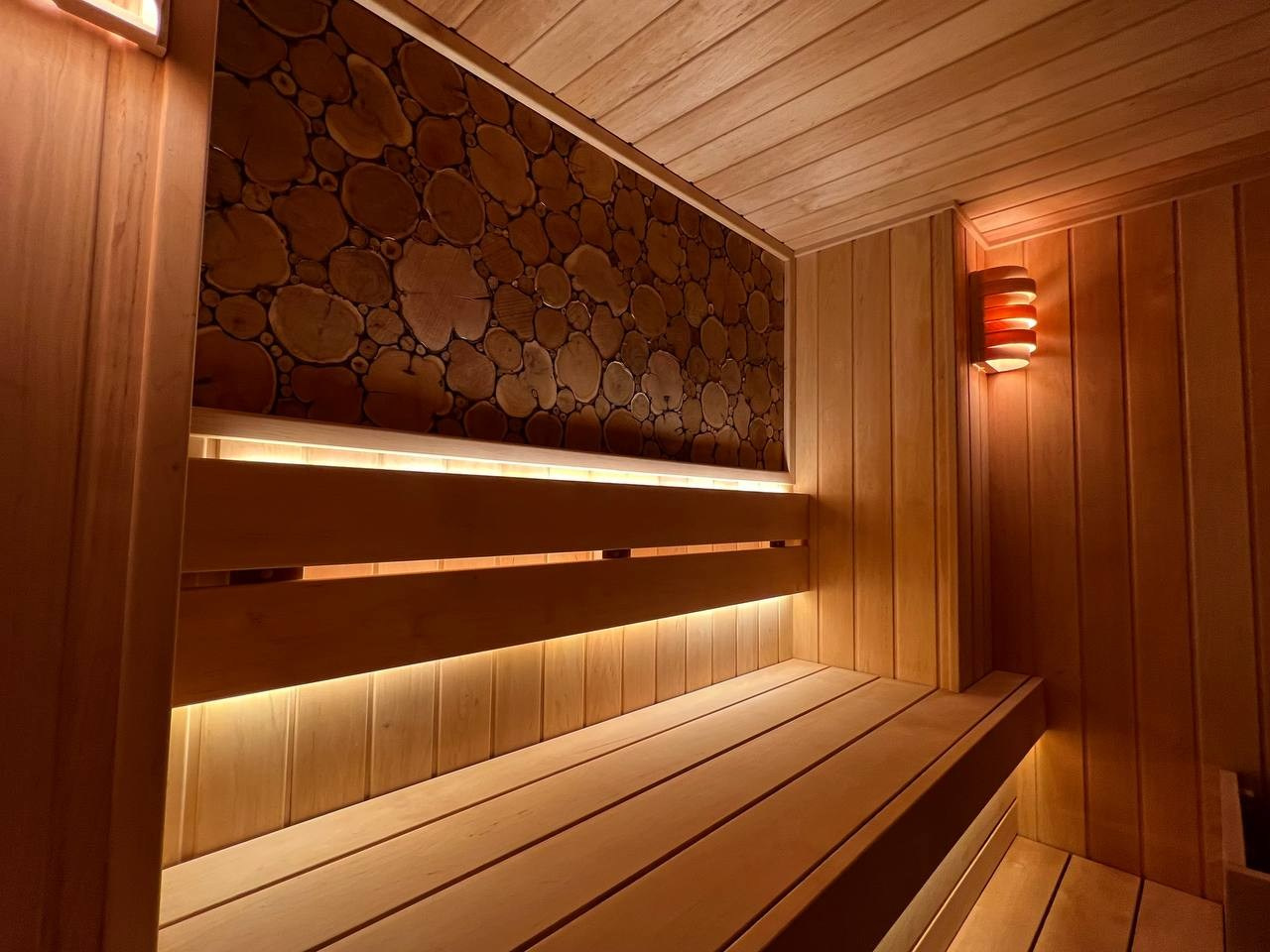 Уютная сауна на Петроградке из белорусской ольхи с можжевеловым панно, винтажными светильниками и паром от Harvia Cilindro. SaunaTopMasters