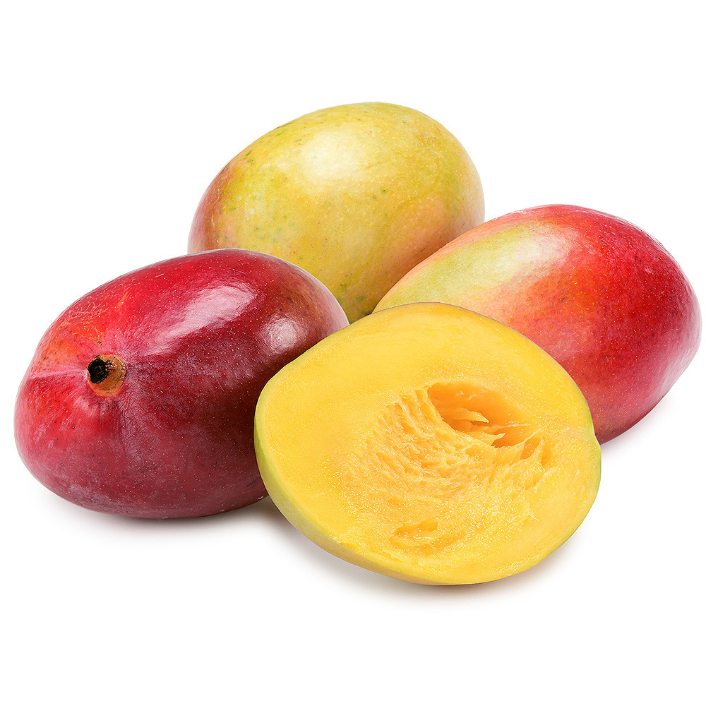 жёлто-красные манго лежат на белом фоне, одно манго разрезано.