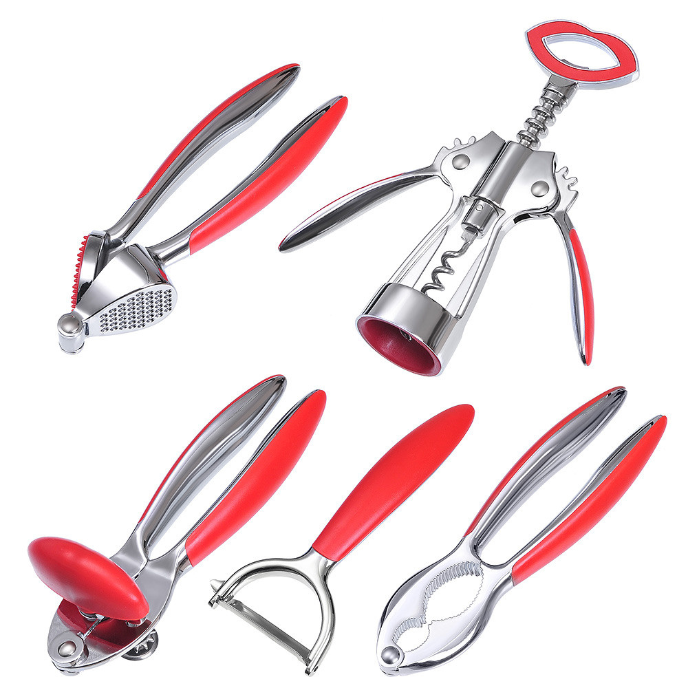 набор для кухни из металлических предметов с красными ручками на белом фоне