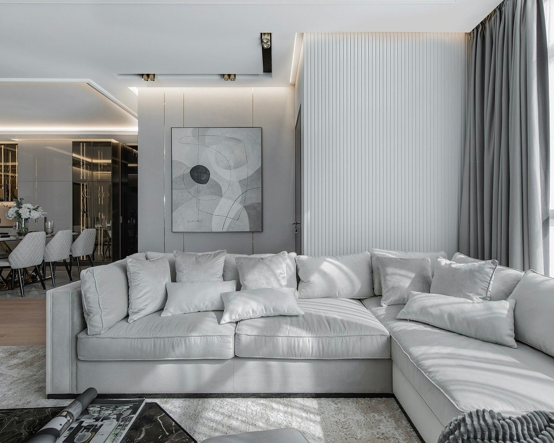 Современный интерьер гостиной с серым диваном и декоративной панелью — дизайн Валерии Котович