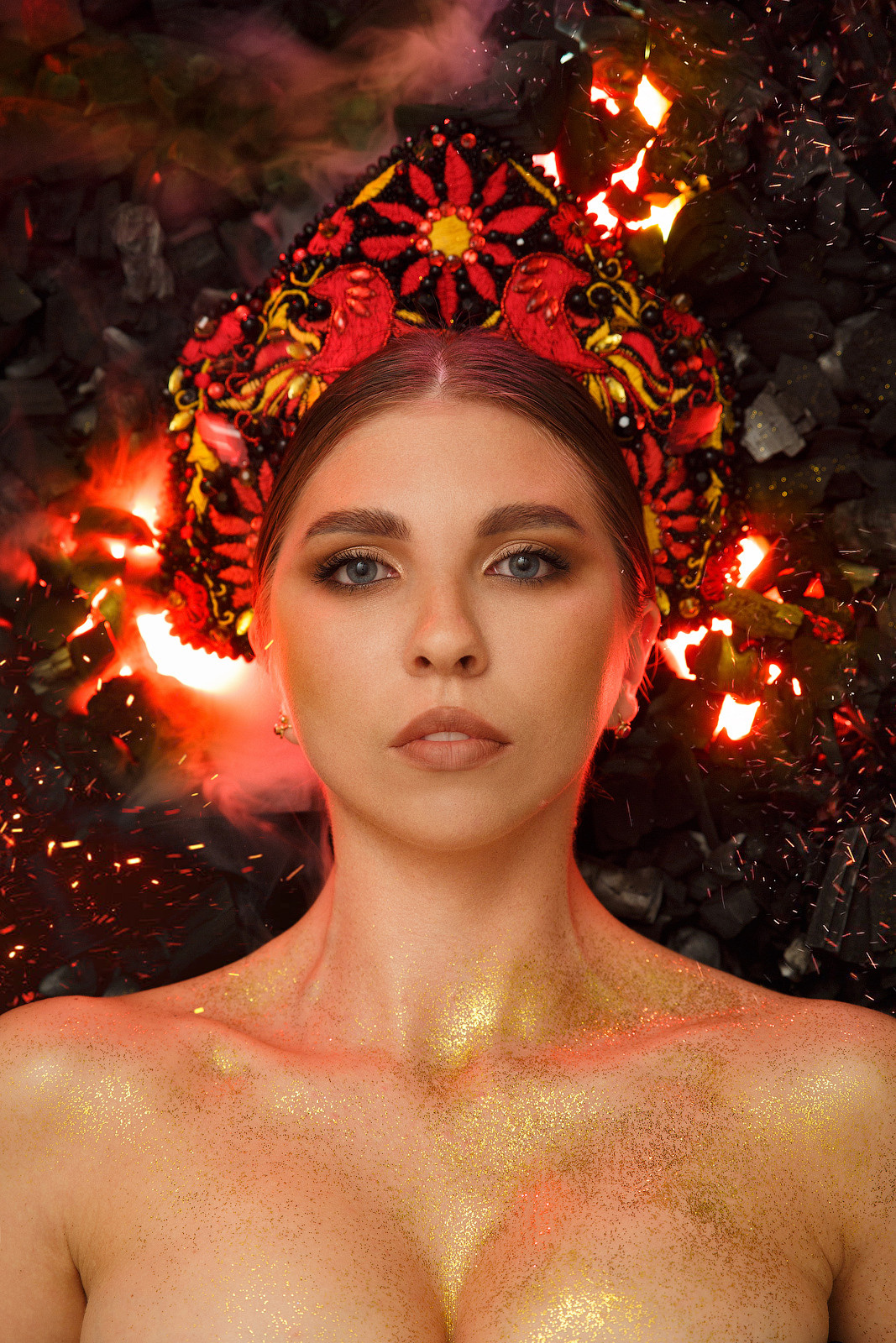 Съёмка сделана в домашних условиях, без какого-либо прописанного плана. За день были найденные необходимые детали и вечером преступили к съёмке. Для съёмки понадобилось:— 5кг угля купленного в магните,— три чёрных листа картона,— один одолженный вейп у Михаила Белоусова,— три rgb панельки видео света купленные в Фотомагазин Фотомаг59 на Сибирской, 22в (зарытые в уголь),— один галогенновый моноблок на 1000w (направлены в потолок),— одна настольная лампа и палка из леруа мерлен (+ красный скотч) для контрового света,— кокошник ручной работы от Марии Кравец,— золотистый глиттер (который теперь валяется по всему дому),— камера + штатив.Model: Мария КравецИдея съёмки жила в голове уже несколько лет, после просмотра фильма — «Он — драко́н»