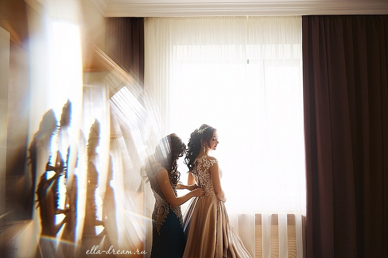 Подружка собирает невесту в номере отеля с отражениями