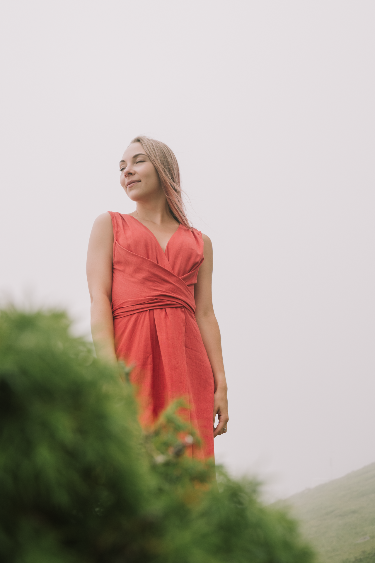 Сбоку кадр девушки на фоне зелени и облаков