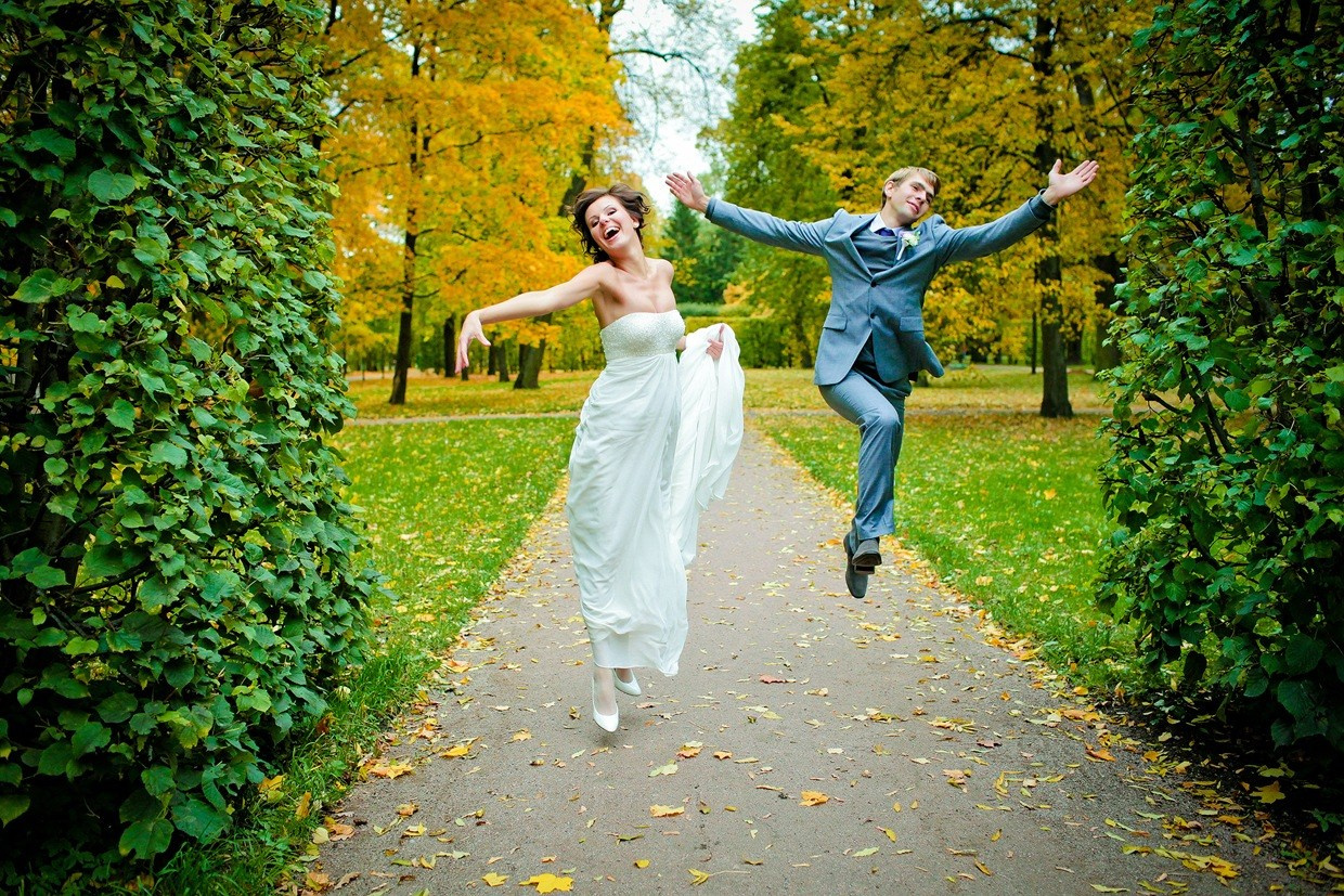 жених и невеста подпрыгивают на гравиевой дорожке в паке