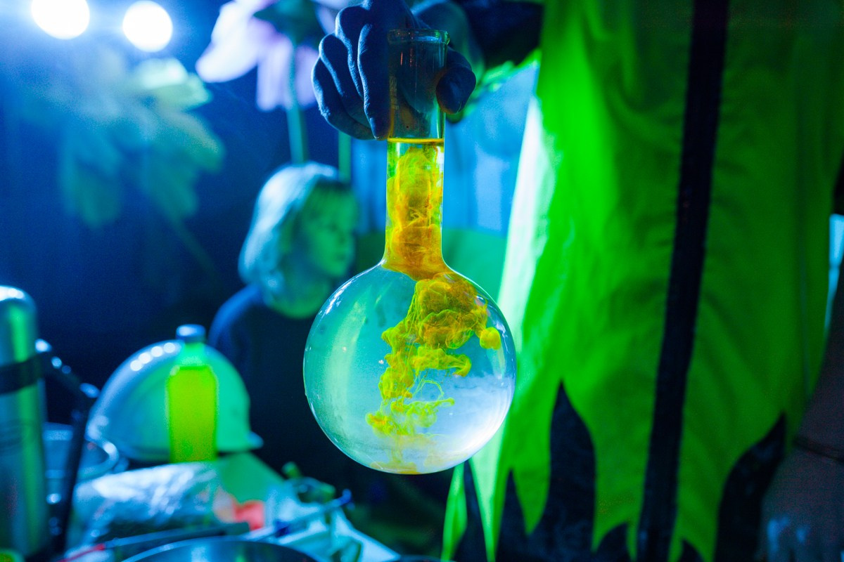 желтая субстанция красиво растворяется в колбе на химическом шоу для детей