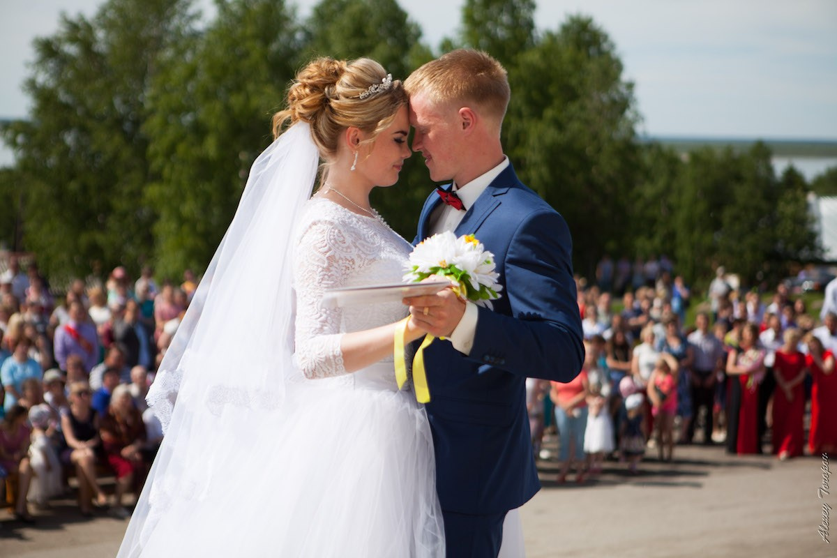Первый танец молодожёнов на деревянном помосте, украшенном гирляндами и цветами