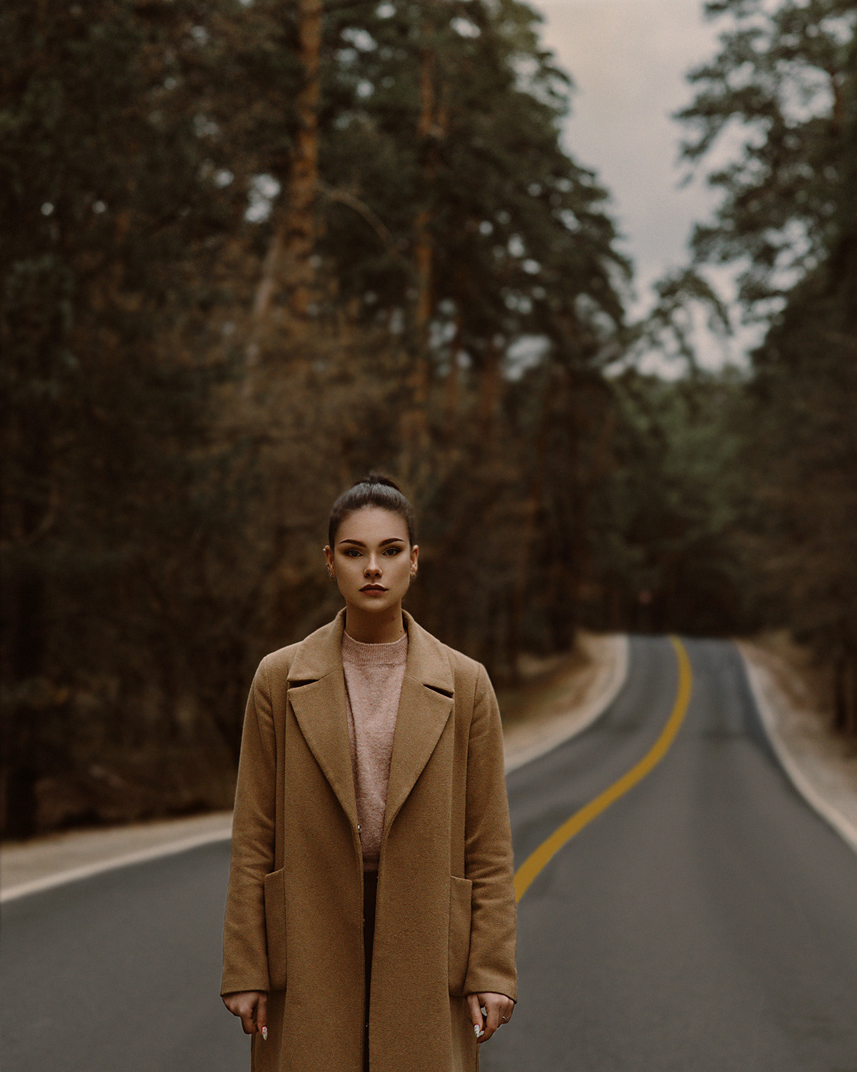 Девушка на проселочной дороге среди сосен. Съемка в стиле кино. Темная обработка