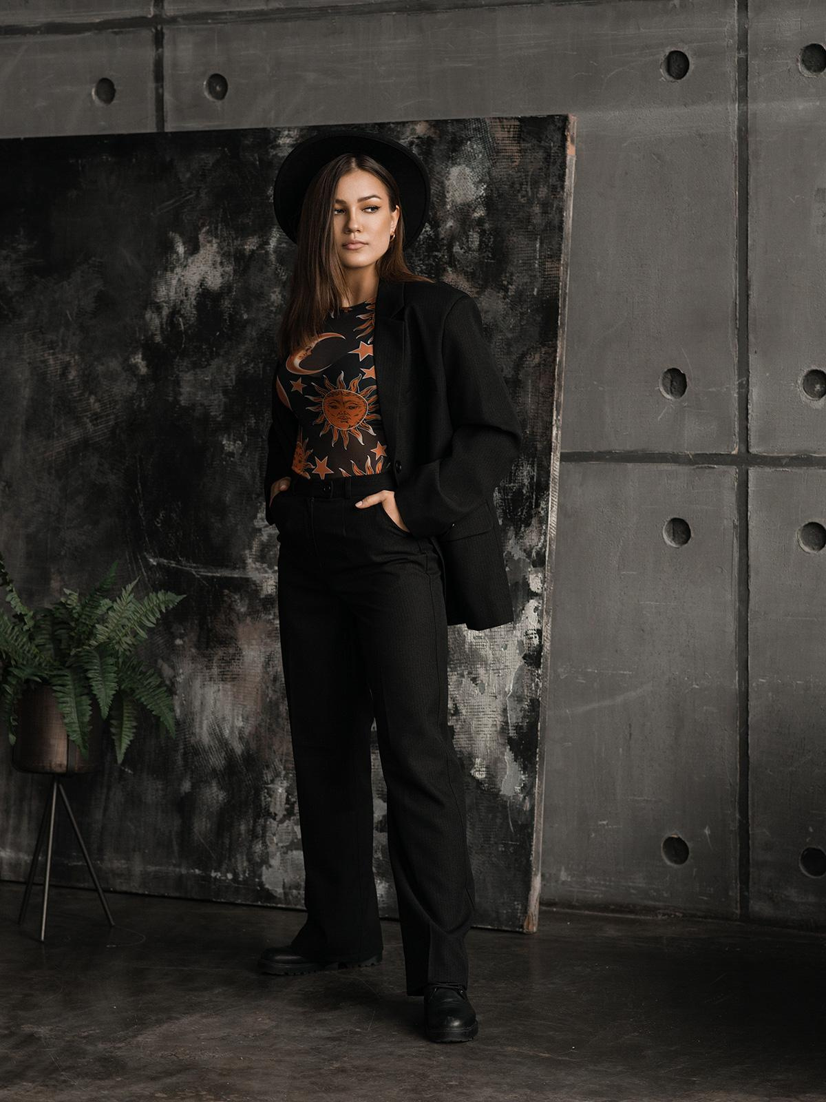 Фотосессия девушки в строгом костюме и шляпе в студии. 