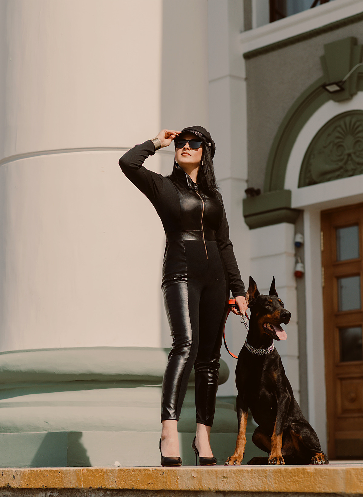 Фотосессия девушки с доберманом в черном костюме на площади