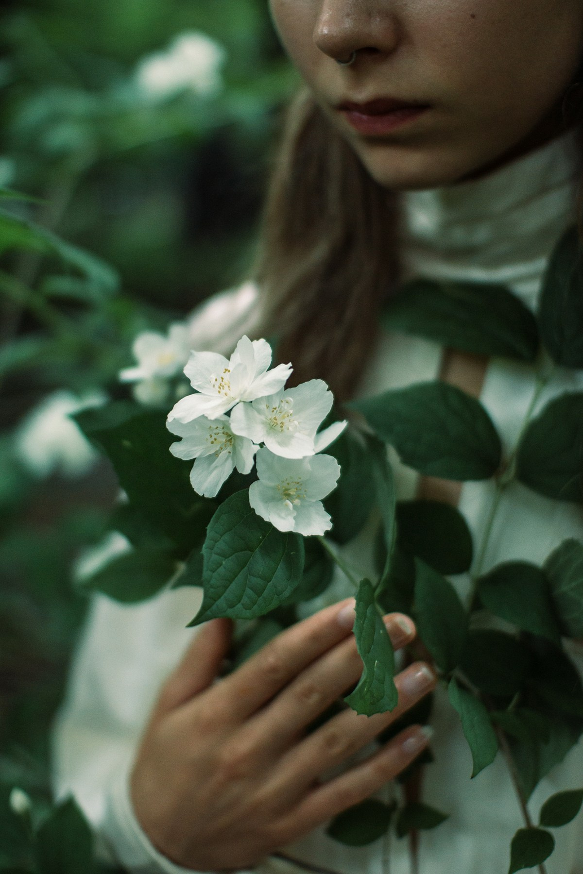 Девушка держит в руках ветку жасмина