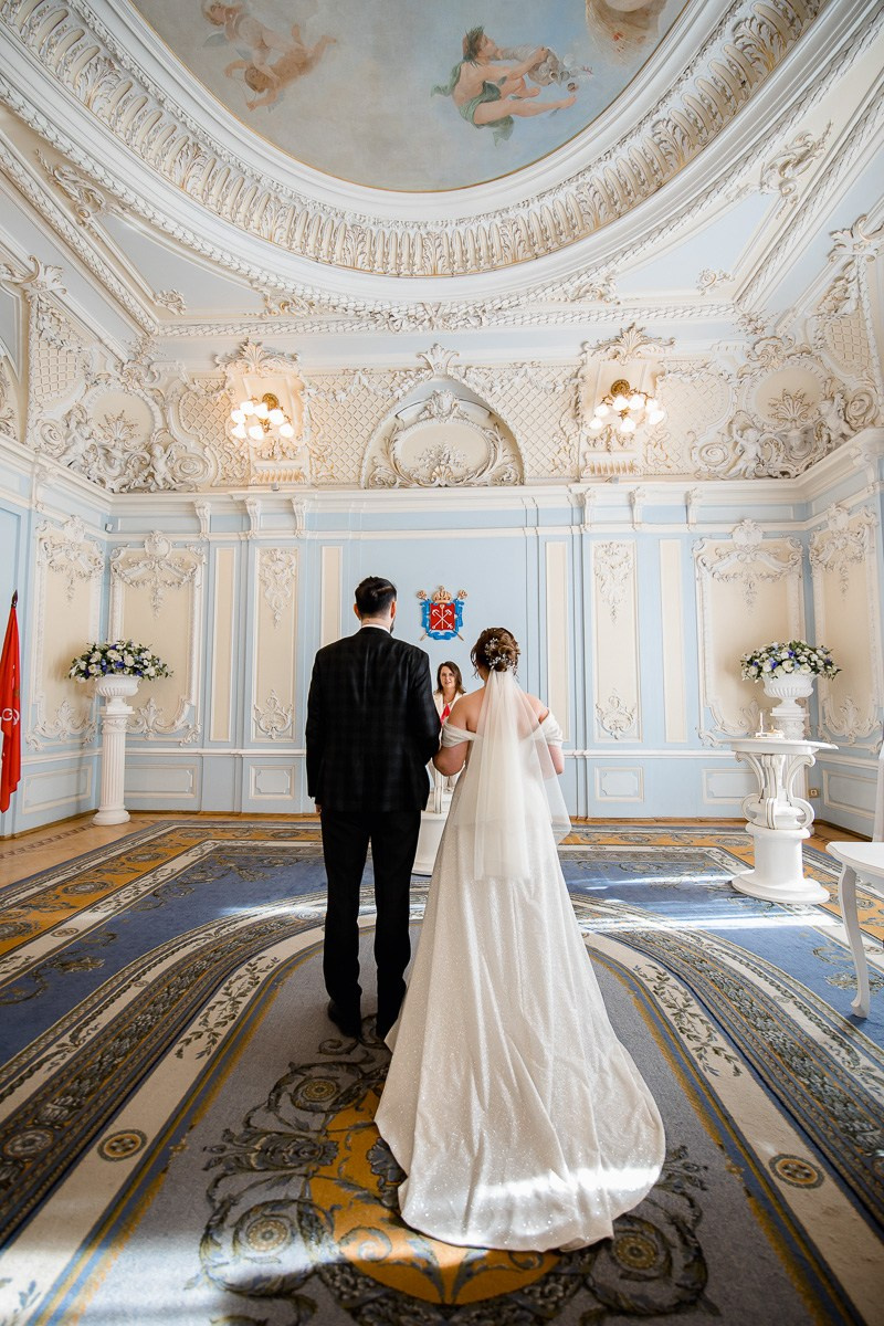 Жених и невеста в зале регистраций в ЗАГСе на фурштатской СПб. Вертикальный кадр, Вид сзади