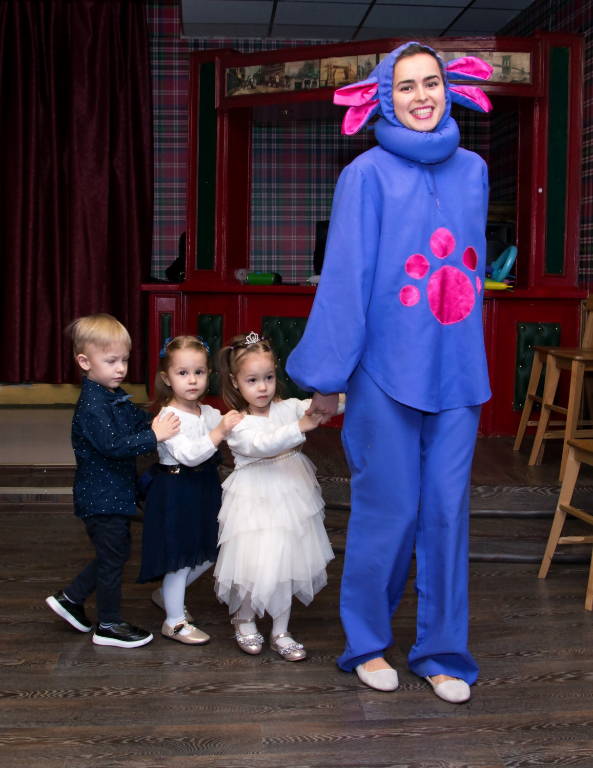 За ручки взяв друг друга малыши паровозиком идут за зайцем