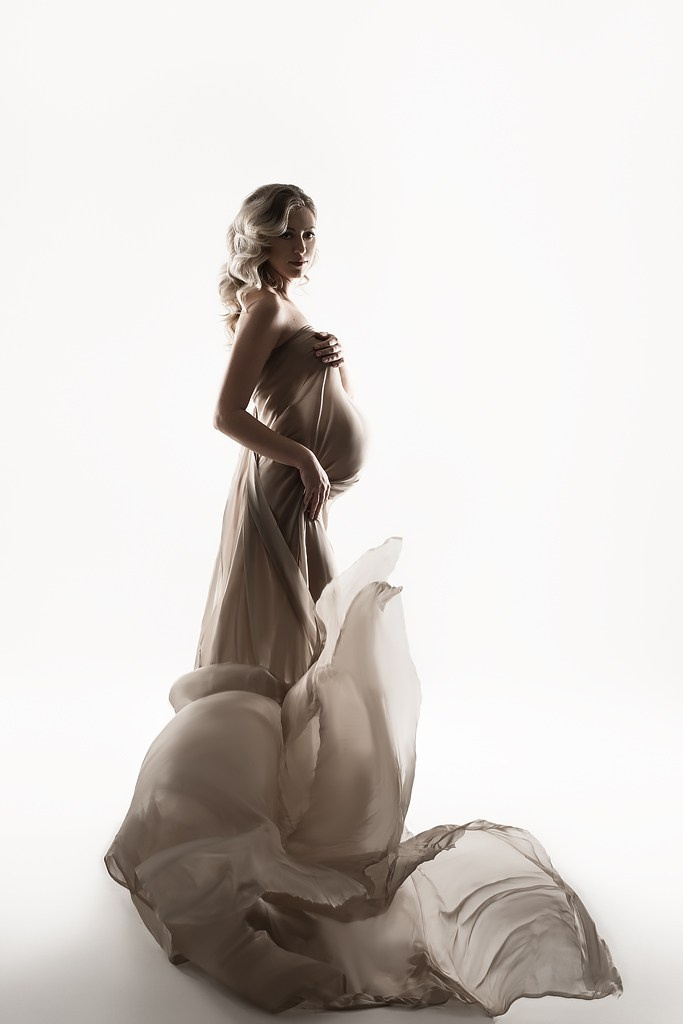фотосессия беременной в фотостудии на светлом фоне в красивом разлетающемся платье, фотография беременности, фотосессия беременных, портрет беременной
