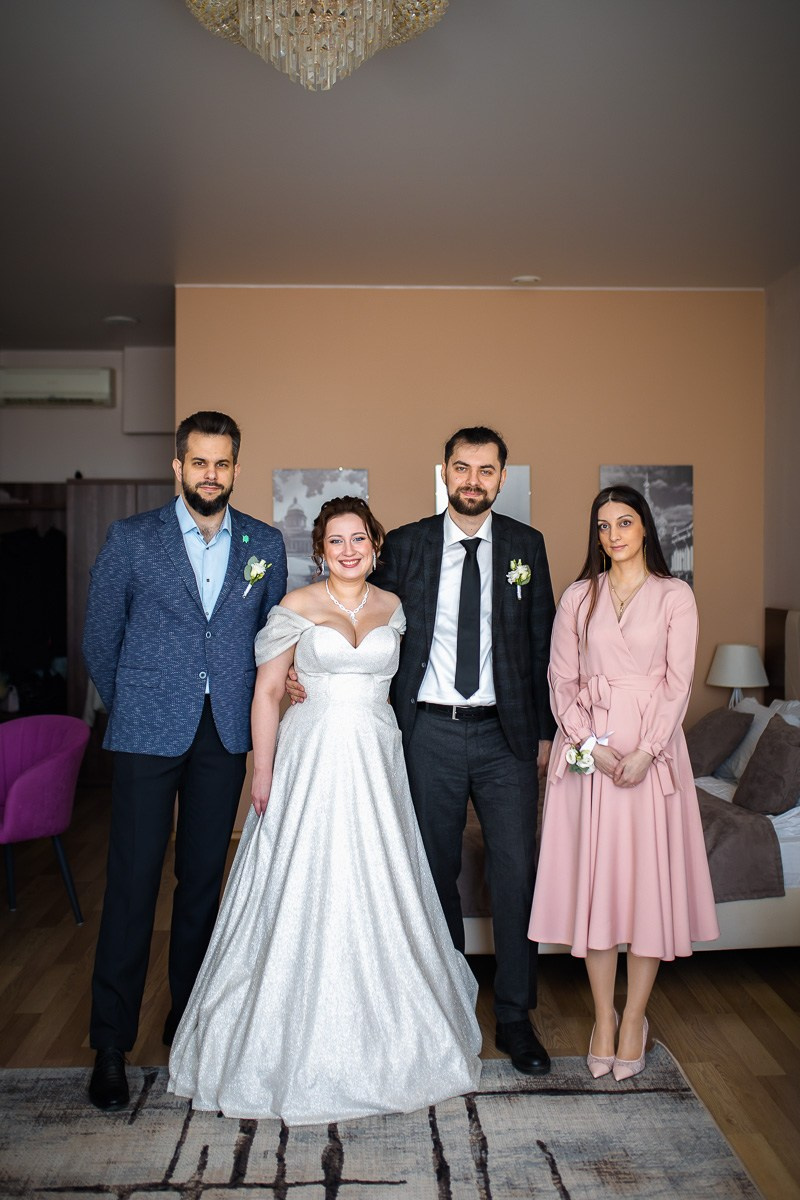 Портрет жениха и невесты с родными в номере отеля